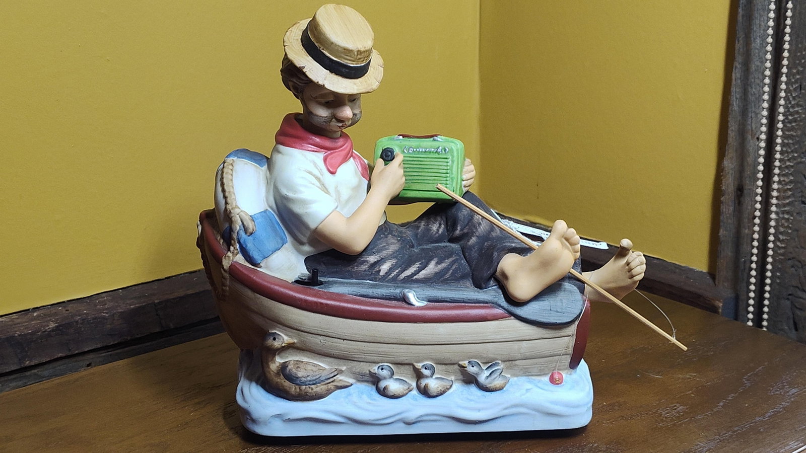 Seiji Nakane Melody In Motion 'Fisherman' Figurine: This is an animated musical porcelain figurine produced by Melody In Motion, cast from an original sculpture by artist Seiji Nakane. The hand-painted piece depicts a barefoot fisherman relaxing in a r