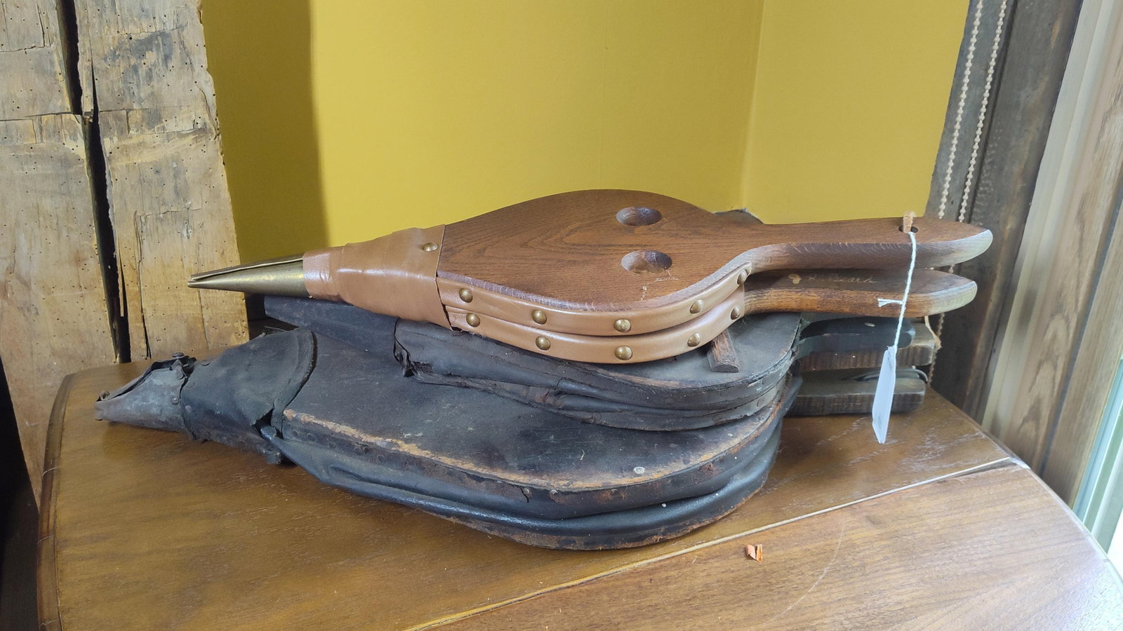 4 Fireplace Bellows, one signed J. R. Beard: A group of four hand-operated fireplace bellows constructed from wood, leather, and metal. The uppermost example features light-colored oak handles and body, joined with tan leather and decorative
