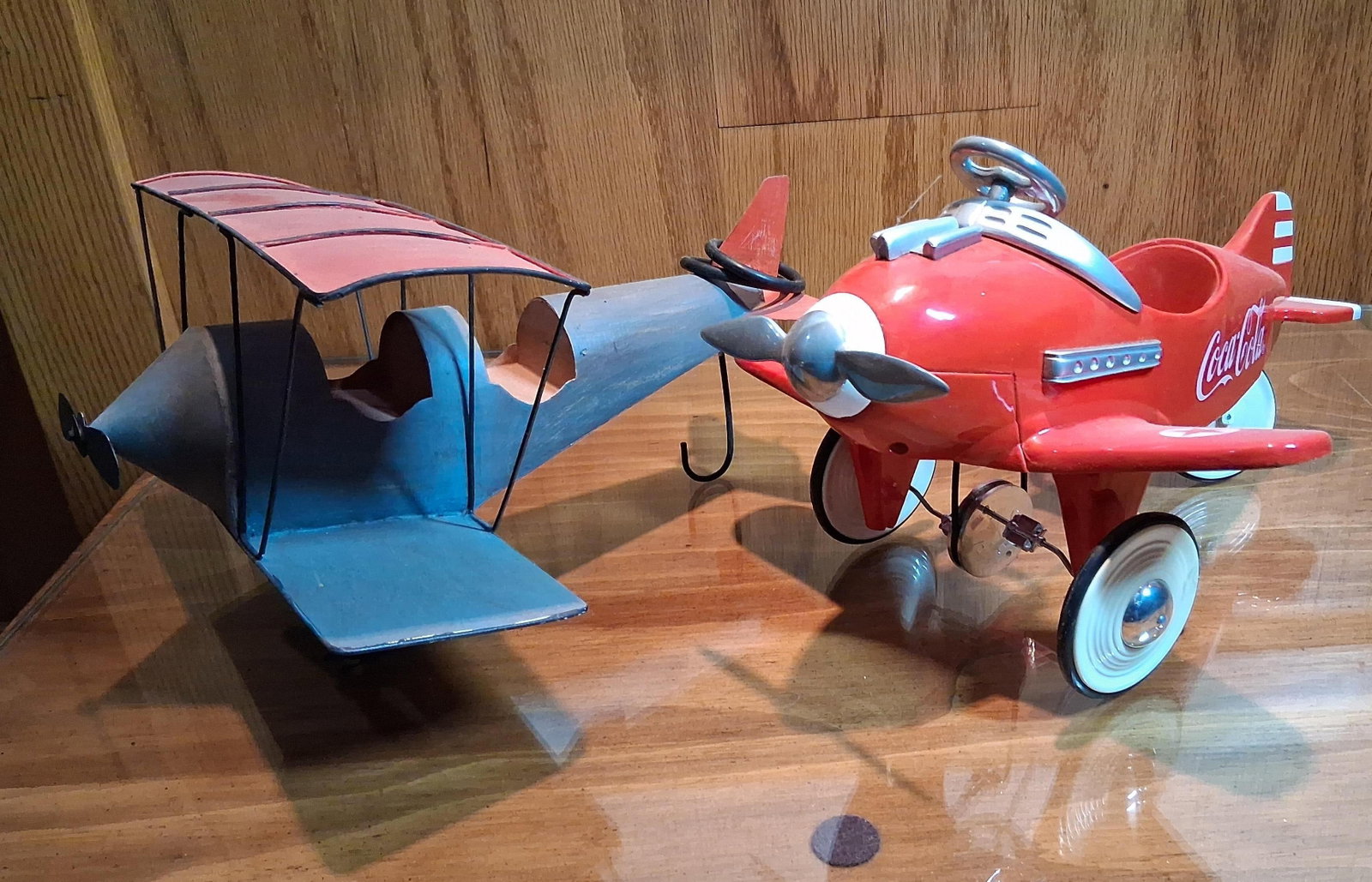 Pair Xonex Coca-Cola Limited Edition Toy Airplanes: This lot features two toy airplanes. The first is a limited edition Coca-Cola model airplane manufactured by Xonex in 1995. This die-cast metal toy is designed in the style of a vintage pedal plane an
