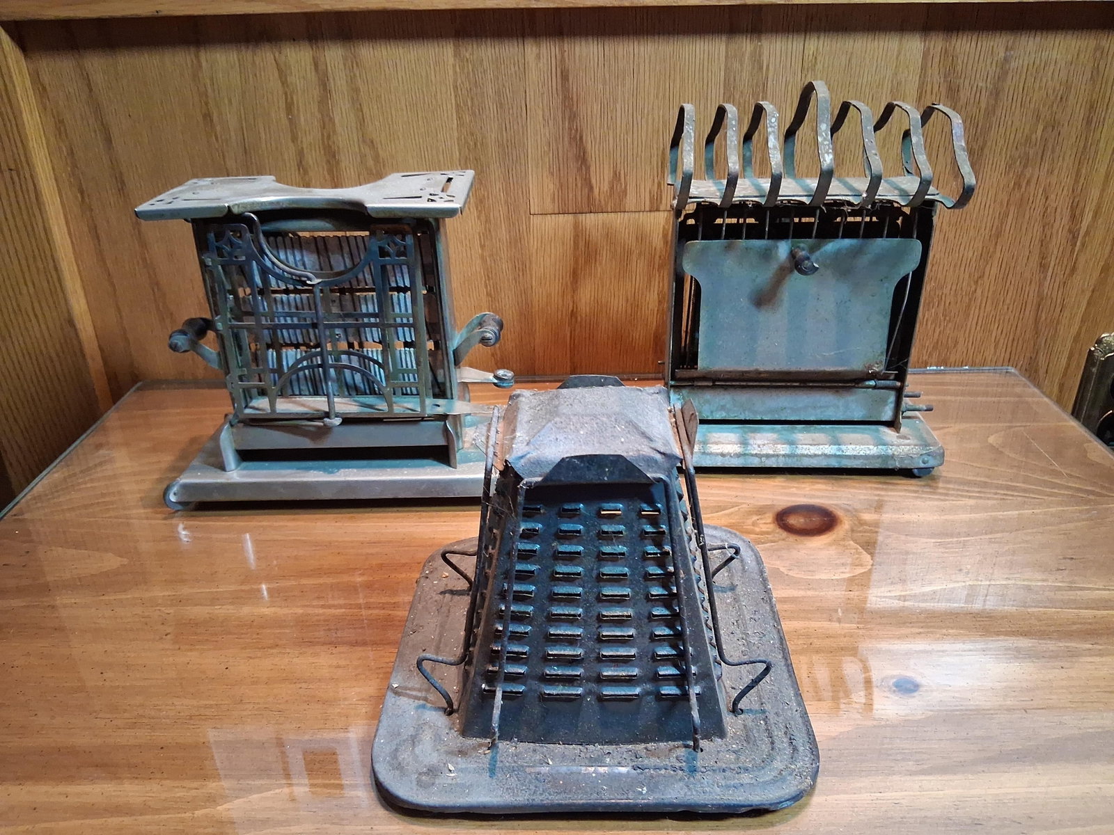 Universal & Simplex Antique Toasters, Set 3: A trio of early 20th-century toasters featuring two electric side-loading models and one stovetop model. One electric unit is identified as a Universal model E 947, manufactured by Landers, Frary & Cl