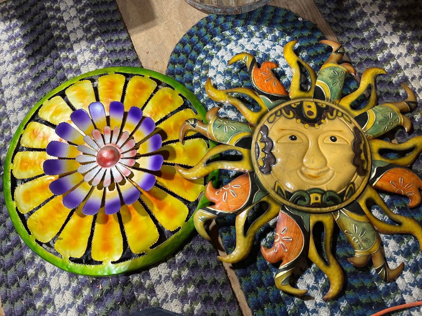 Pair Mexican Folk Art Painted Metal Wall Hangings: This lot consists of two decorative wall hangings in the style of Mexican folk art, both constructed from painted sheet metal. The first item is a celestial sun motif featuring a central embossed