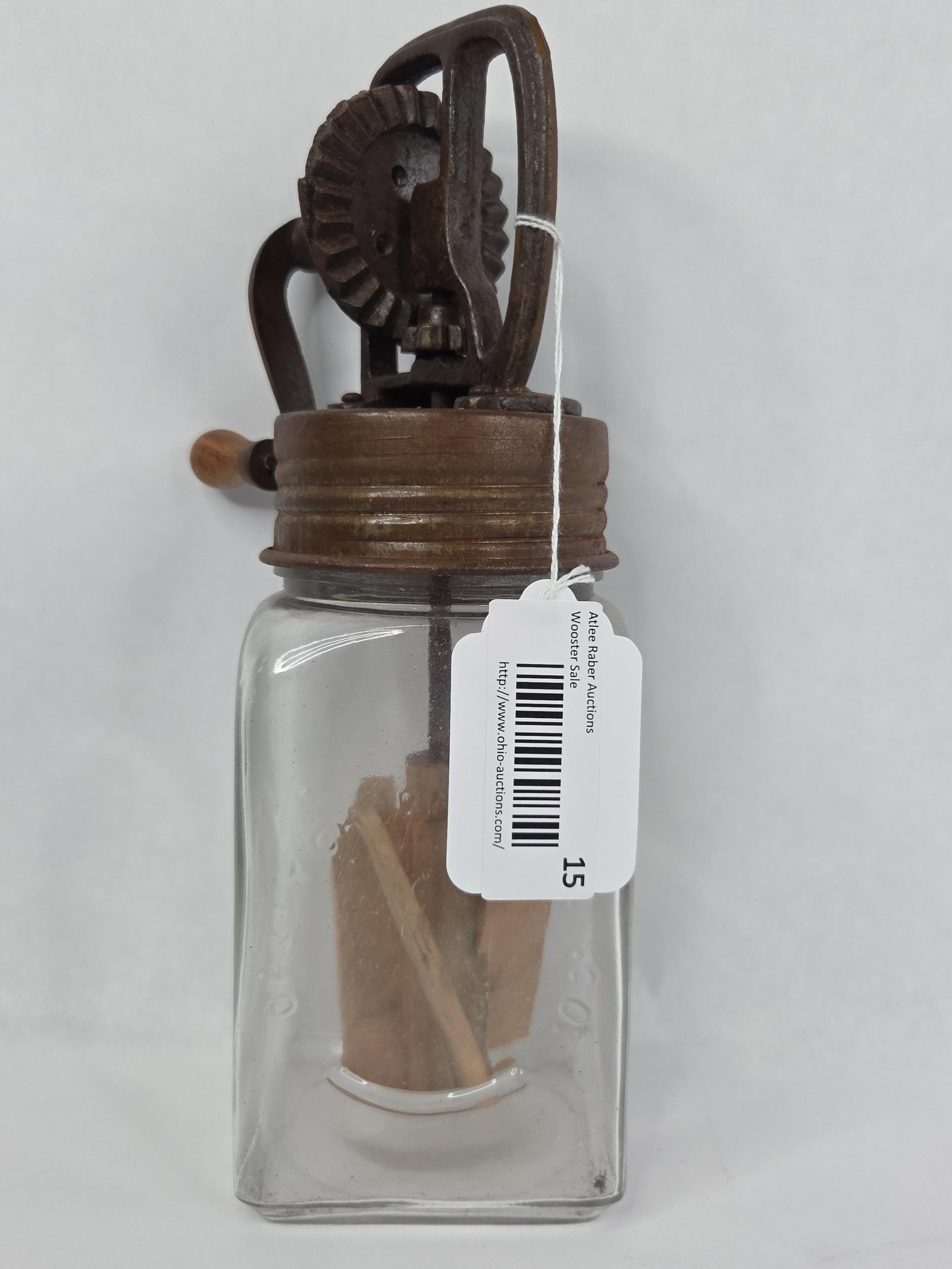 #NAME?: This item is a hand-cranked butter churn, designed in the style of early 20th-century glass jar churns. The assembly consists of a clear rectangular glass jar with rounded corners and a screw-on cast 