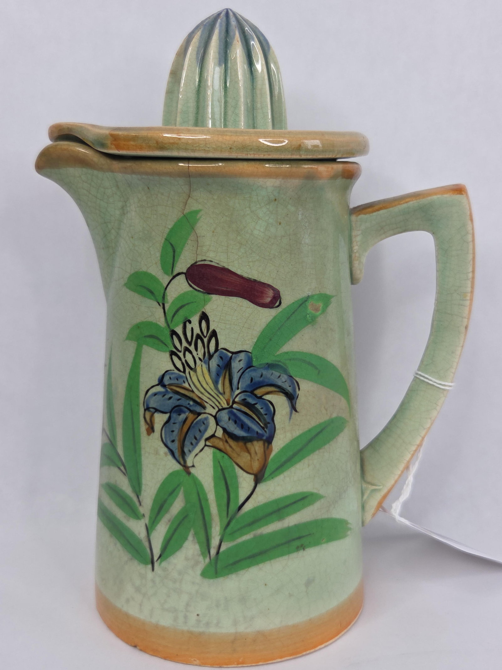Mid-20th Century Japanese Hand-Painted Ceramic Citrus Reamer Pitcher: A two-piece ceramic citrus reamer and pitcher set produced in Japan. The set is made of earthenware and features a cylindrical pitcher with a pouring spout and a D-shaped handle. The removable lid is
