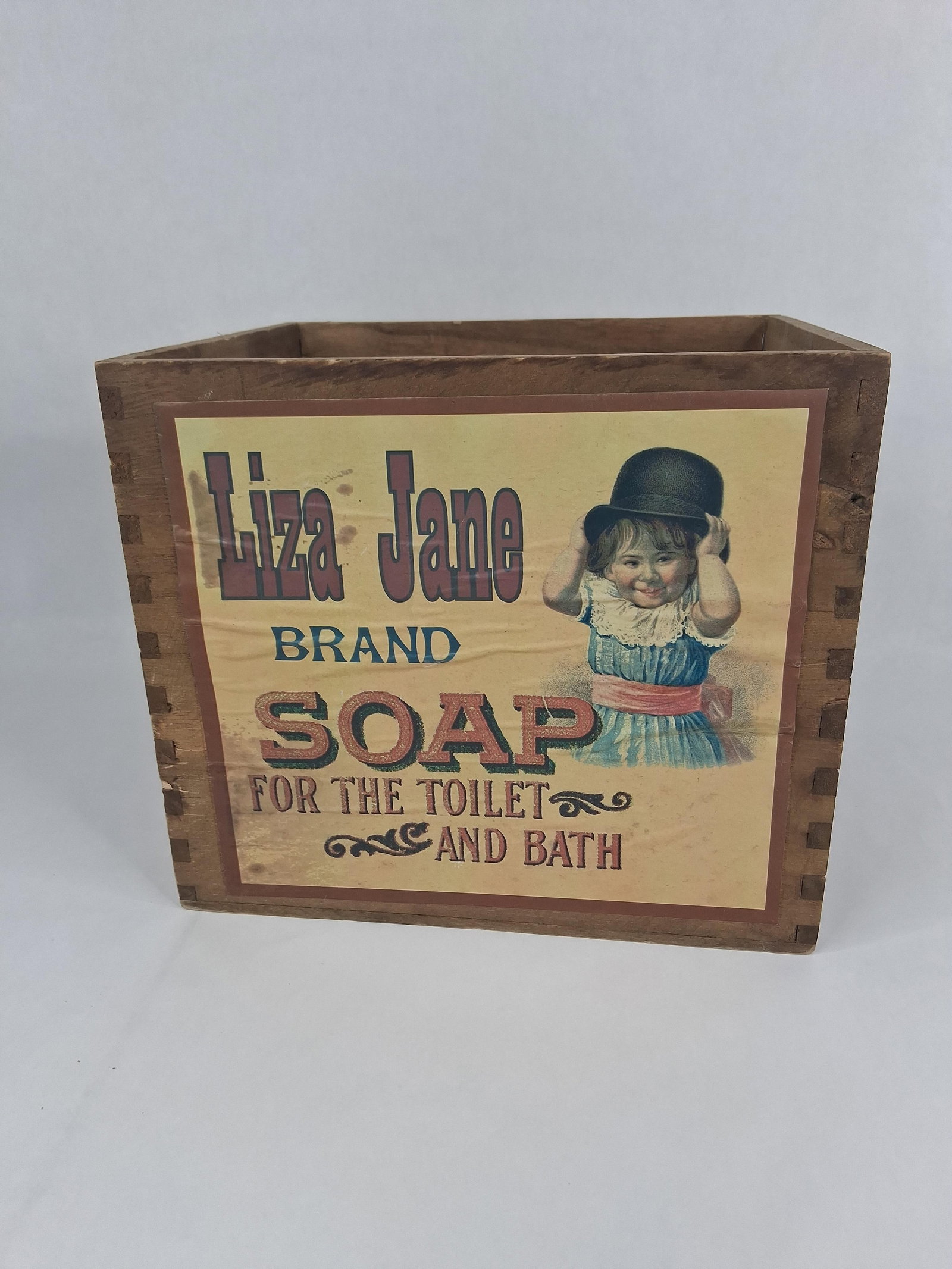 Liza Jane Soap Advertising Wooden Crate: A square wooden box or crate featuring an applied multi-color paper advertising label for Liza Jane Brand Soap. The container is constructed with finger-jointed corners and an open top. The front