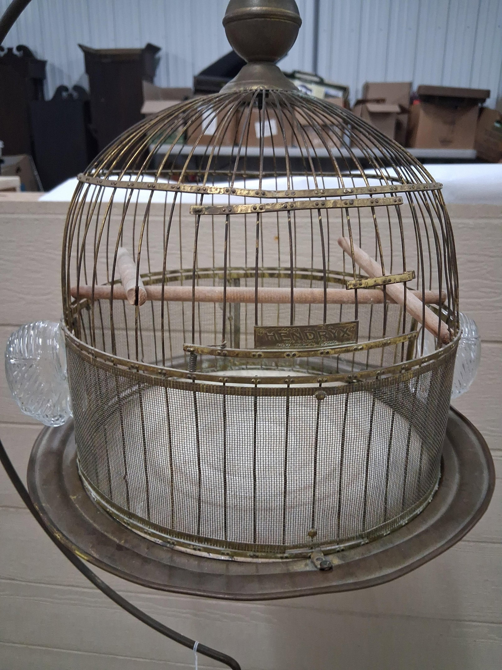 Hendryx Brass Birdcage & Cast Iron Stand: 64in tall This early 20th-century birdcage was produced by the Hendryx company of New Haven, Connecticut. The round cage features a domed top and is constructed of brass-toned metal wire with a fine