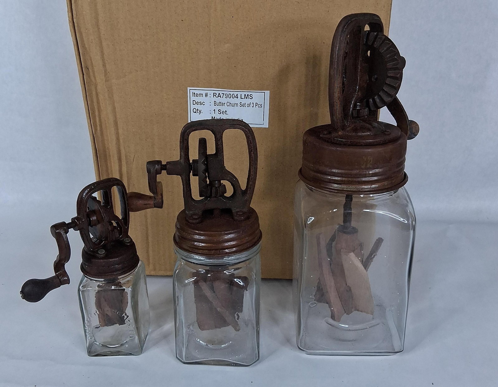 Set 3 Dazey-Style Cast Iron & Glass Butter Churns: This set of three decorative butter churns consists of graduated sizes, designed as contemporary reproductions of Dazey brand churns. Each unit features a square-sided glass jar with embossed text
