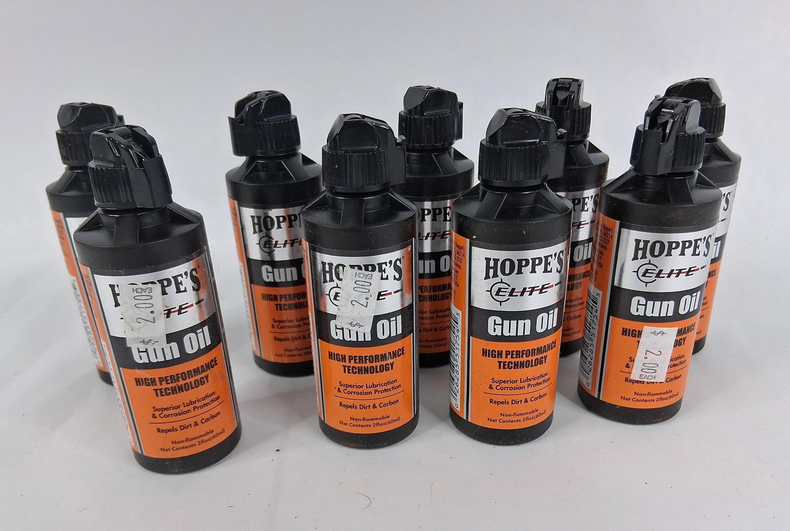 A Lot of 10 Bottles of Hoppe's Elite Gun Oil: This lot consists of ten individual bottles of Hoppe's Elite Gun Oil, each containing 2 fluid ounces (60ml) of synthetic lubricant. These black plastic bottles are designed for precision maintenance,