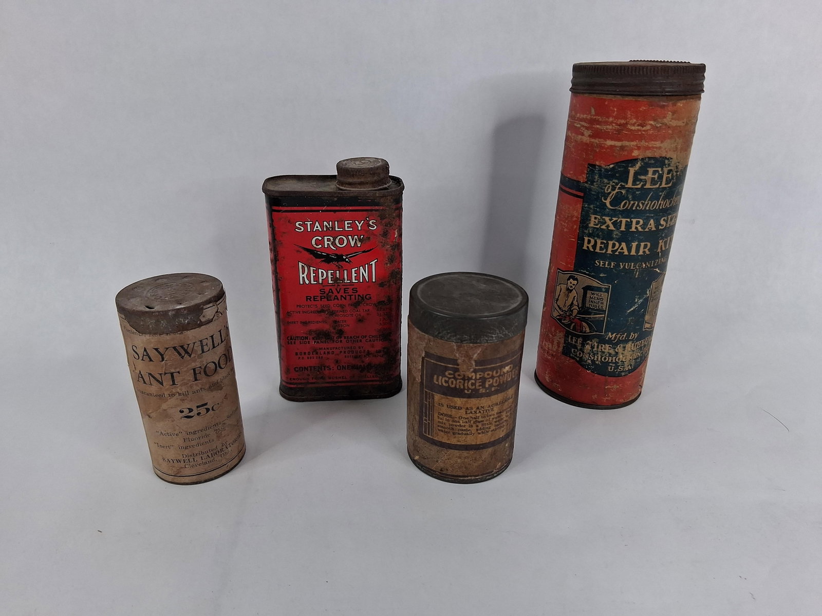 A Collection of Four American Advertising Tins and Containers Including Stanley's Crow Repellent: This collection features four advertising containers from the early to mid-20th century, manufactured in the United States. The group includes a lithographed metal tin for Stanley?s Crow Repellent, ma