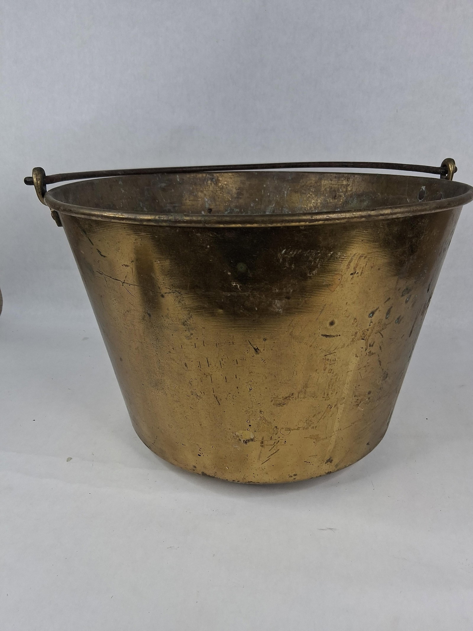 19th C. American Spun Brass Kettle w/ Iron Bail: 14.5 dia 11in tall An antique spun brass kettle of American origin, dating to the mid-to-late 19th century. The vessel features a tapered cylindrical body with prominent horizontal lines, a
