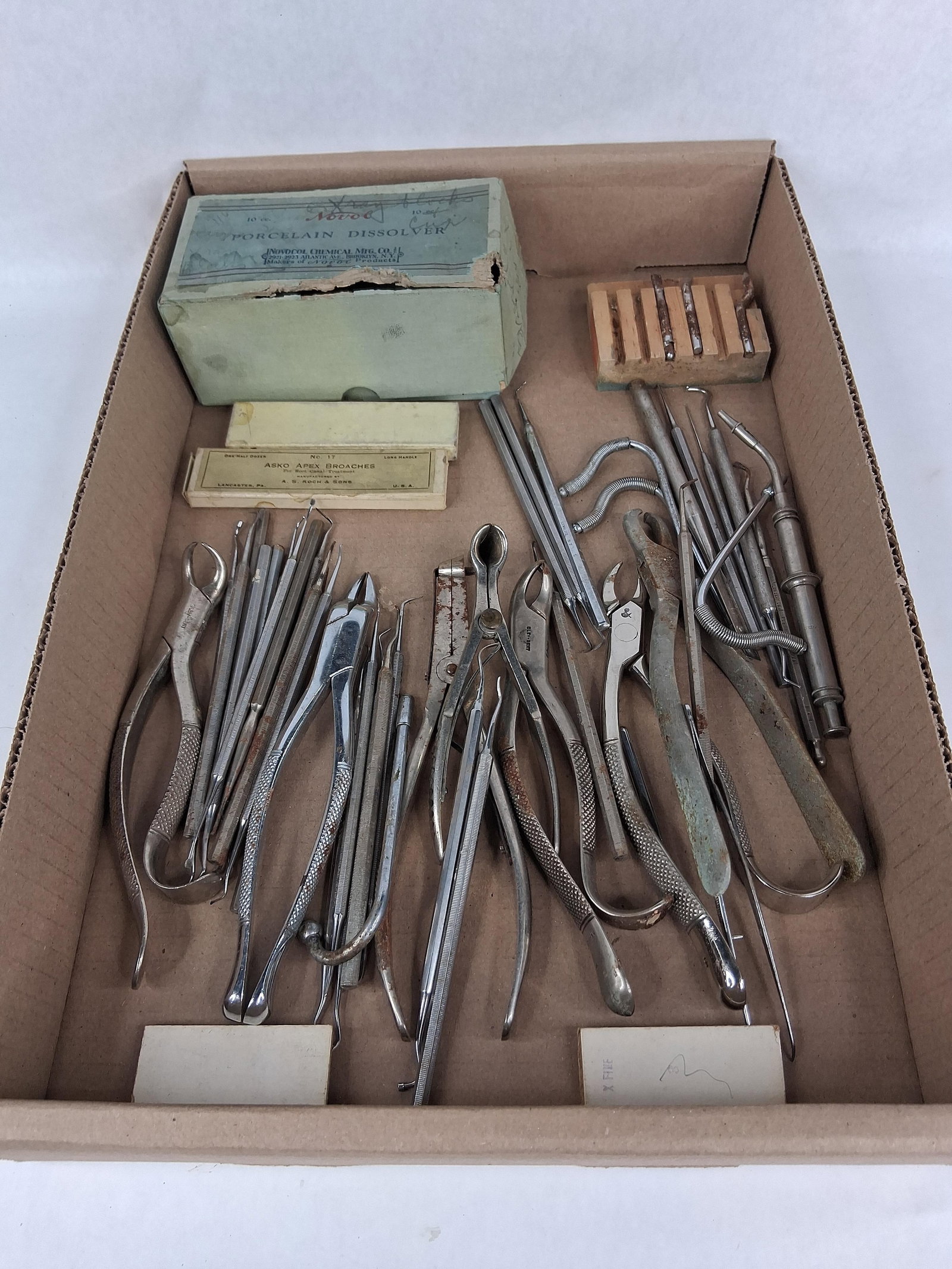 Dental Instruments & Supplies: This collection of dental instruments and supplies features a diverse array of hand tools and specialized equipment primarily from the mid-20th century. The assortment includes multiple pairs of