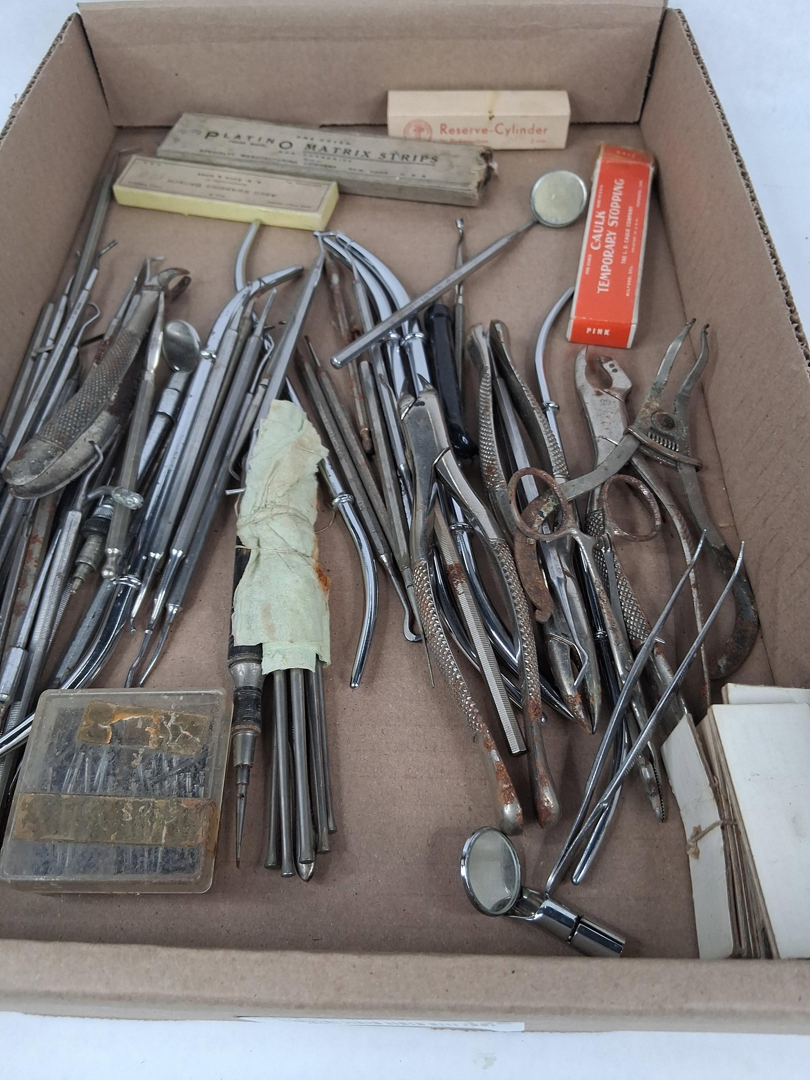 & Antique Dental Instruments & Supplies: A diverse collection of professional dental tools and medical supplies from the early-to-mid 20th century. The assortment includes several pairs of extraction forceps, dental mouth mirrors including