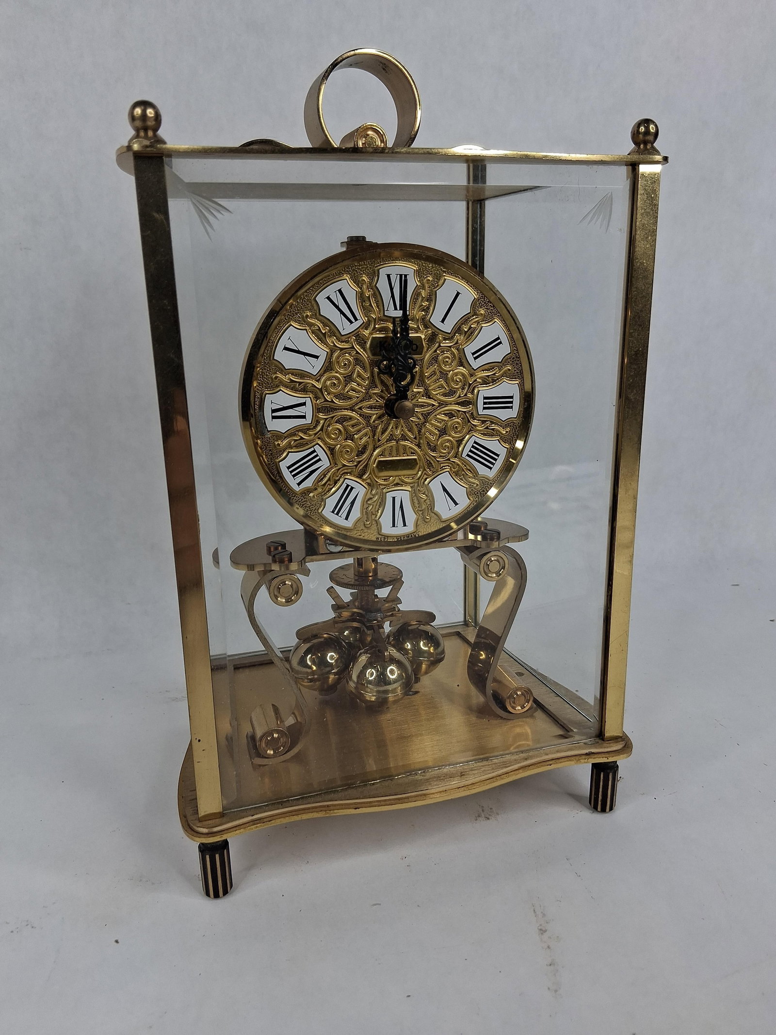 Kundo Kieninger & Obergfell Anniversary Clock: A mechanical torsion pendulum anniversary clock produced by Kieninger & Obergfell under the brand name Kundo. The clock is housed in a polished brass frame with four clear glass panels and features