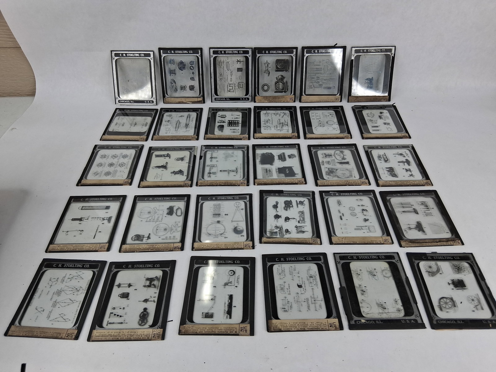 Set 30 C. H. Stoelting Co. Scientific Glass Slides: A collection of 30 scientific educational lantern slides manufactured by the C. H. Stoelting Company. Each slide is constructed from glass plates bound with black paper tape borders. The slides