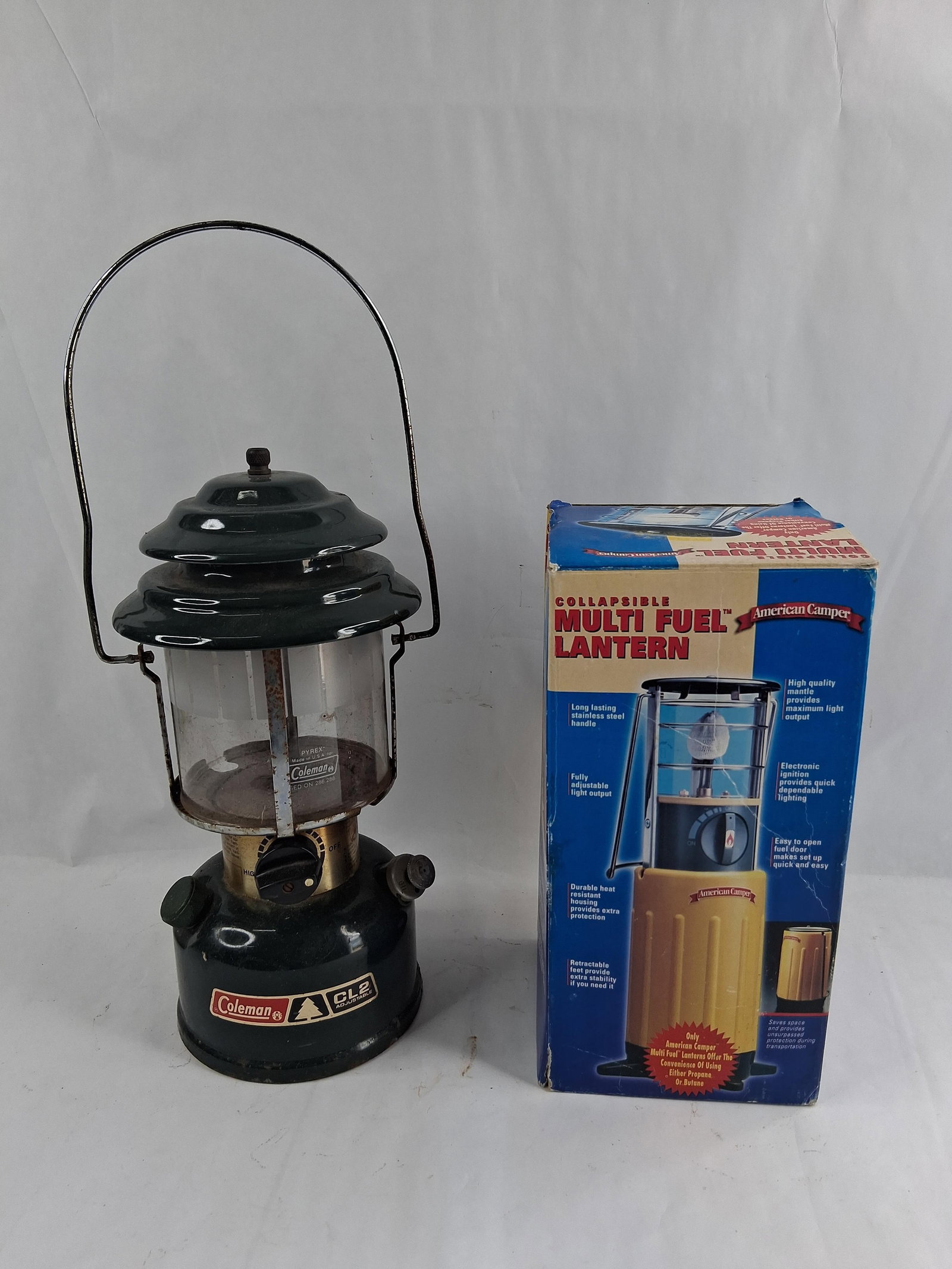Coleman 288 & American Camper 2160BFB Lanterns: This lot contains two portable camping lanterns of different fuel types. The first item is a Coleman Model 288 CL2 Adjustable dual-mantle liquid fuel lantern. It features a dark green enameled