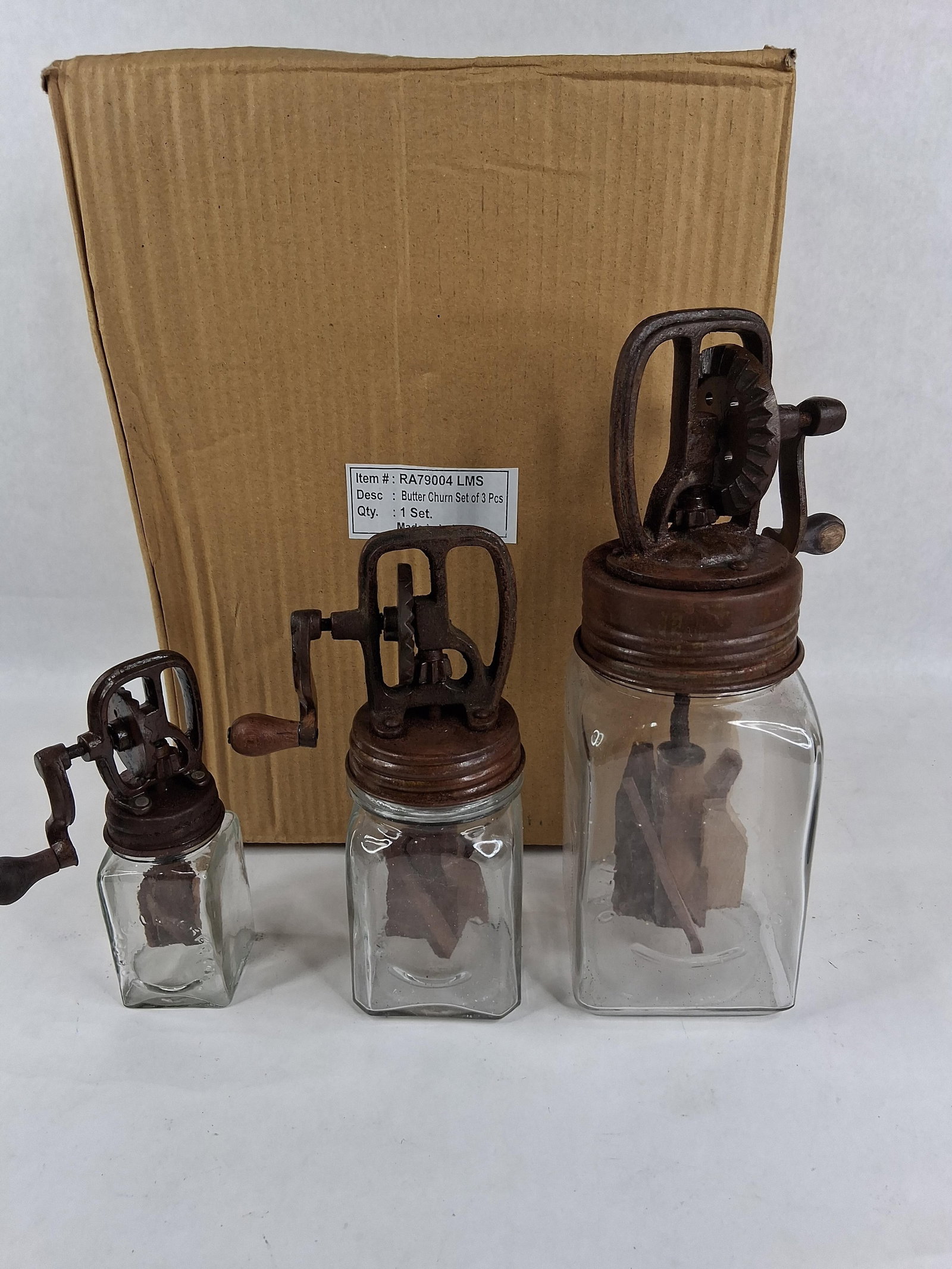 Butter Churn Set of 3 Pcs in the Style of Dazey: A graduated set of three hand-cranked butter churns, produced as modern decorative reproductions in the style of antique Dazey models. Each unit is comprised of a square-shouldered clear glass jar and