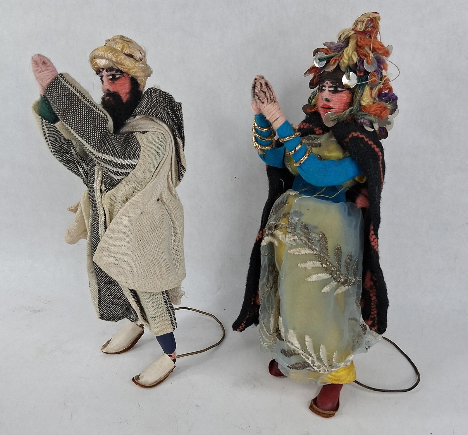 Pair Elmassian Mid-20th C. Middle Eastern Dolls: 11 n tall A pair of handmade folk art dolls representing a male and female figure in traditional regional costume, attributed to the Lebanese maker Elmassian. The dolls are constructed with