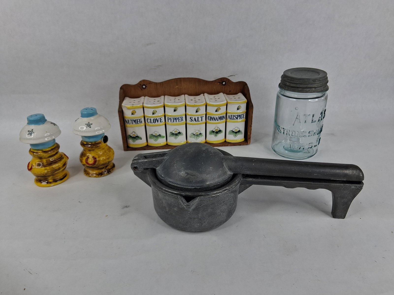Kitchenware: Atlas Mason Jar & Citrus Press: This collection of mid-20th-century kitchenware includes glass, ceramic, and metal functional items. One item is an Atlas Strong Shoulder Mason jar crafted from aqua-tinted glass, featuring a zinc