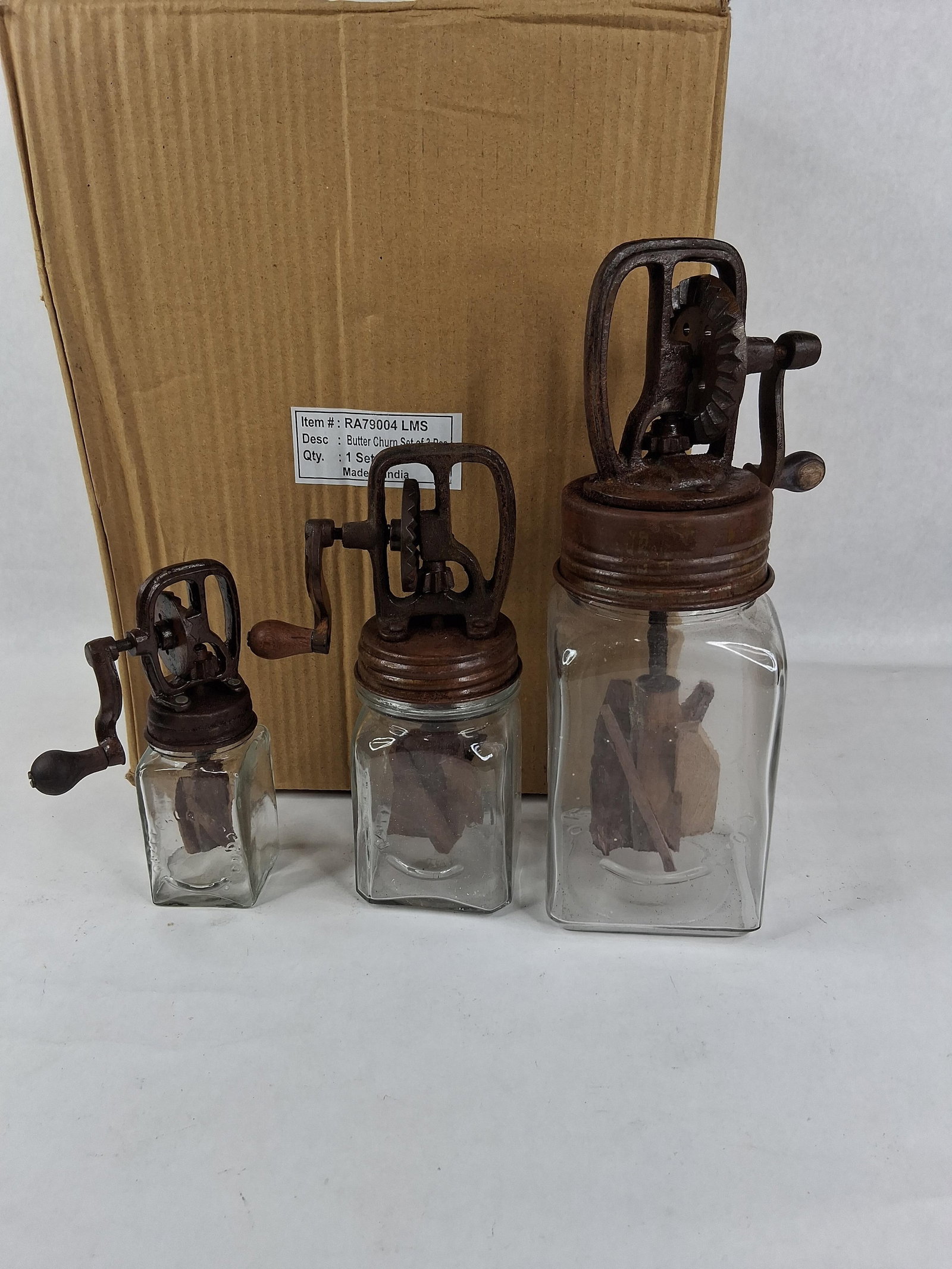 Set 3 Dazey Style Glass & Cast Iron Butter Churns: A set of three decorative glass butter churns in graduated sizes, designed as modern reproductions of antique Dazey models. Each unit consists of a clear glass jar with square sides, a cast metal