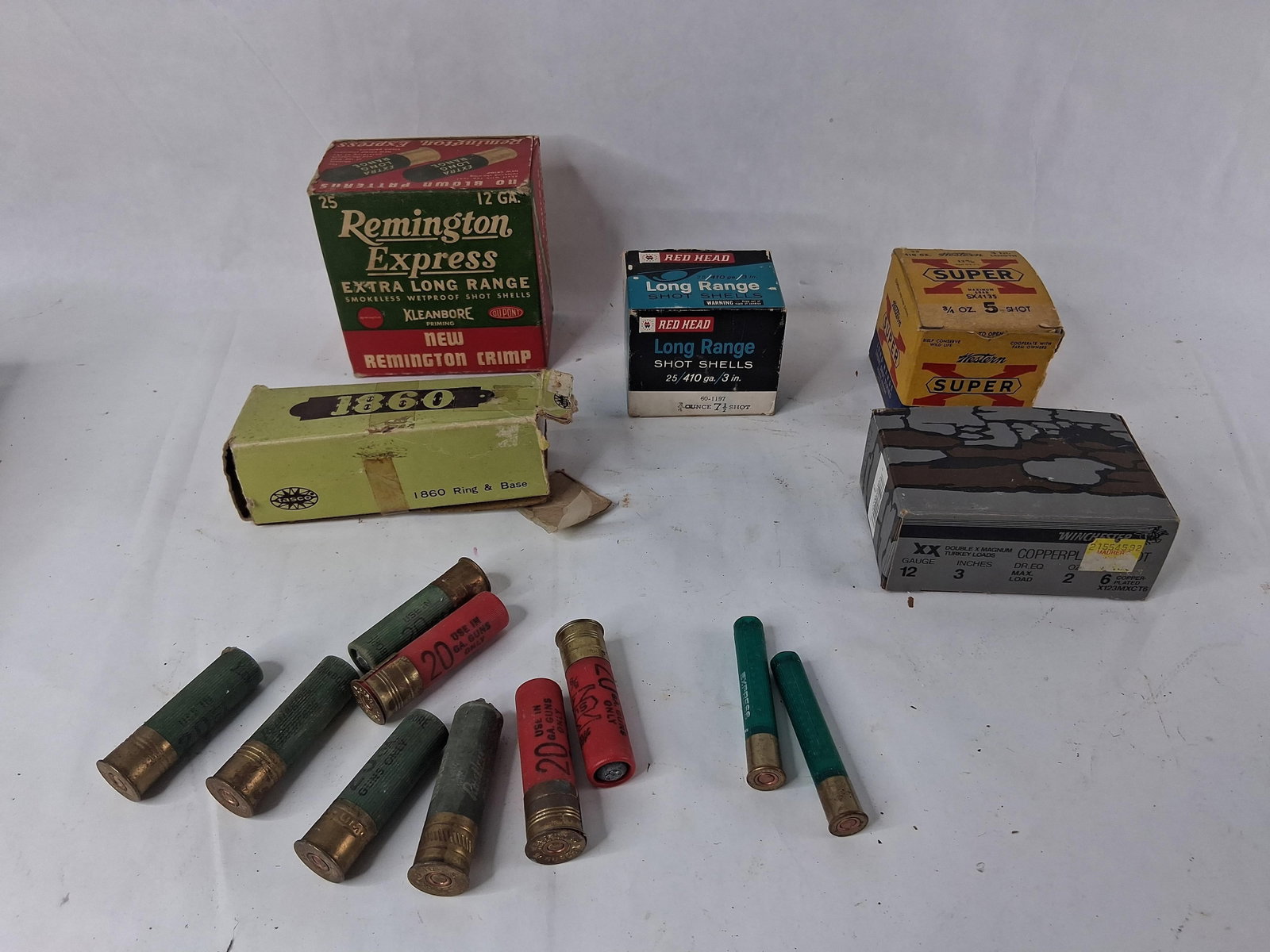 22 Ammunition & Accessory Items w/ 1,800+ .22 LR: This comprehensive collection features a diverse assortment of ammunition and firearm accessories. The lot includes four boxes of shotgun shells: a Remington Express 12-gauge box containing four loose
