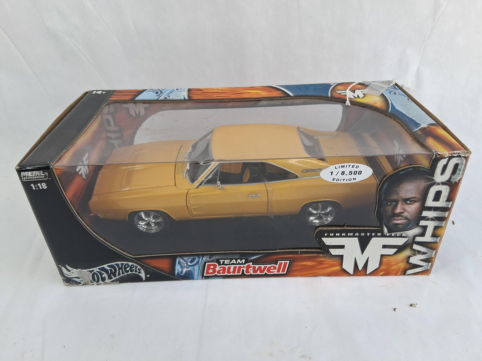 Hot Wheels Funkmaster Flex 1:18 1969 Dodge Charger: Hot Wheels 1:18 scale die-cast model car representing a customized 1969 Dodge Charger, released as part of the Whips collection in collaboration with Funkmaster Flex and Team Baurtwell. The vehicle is
