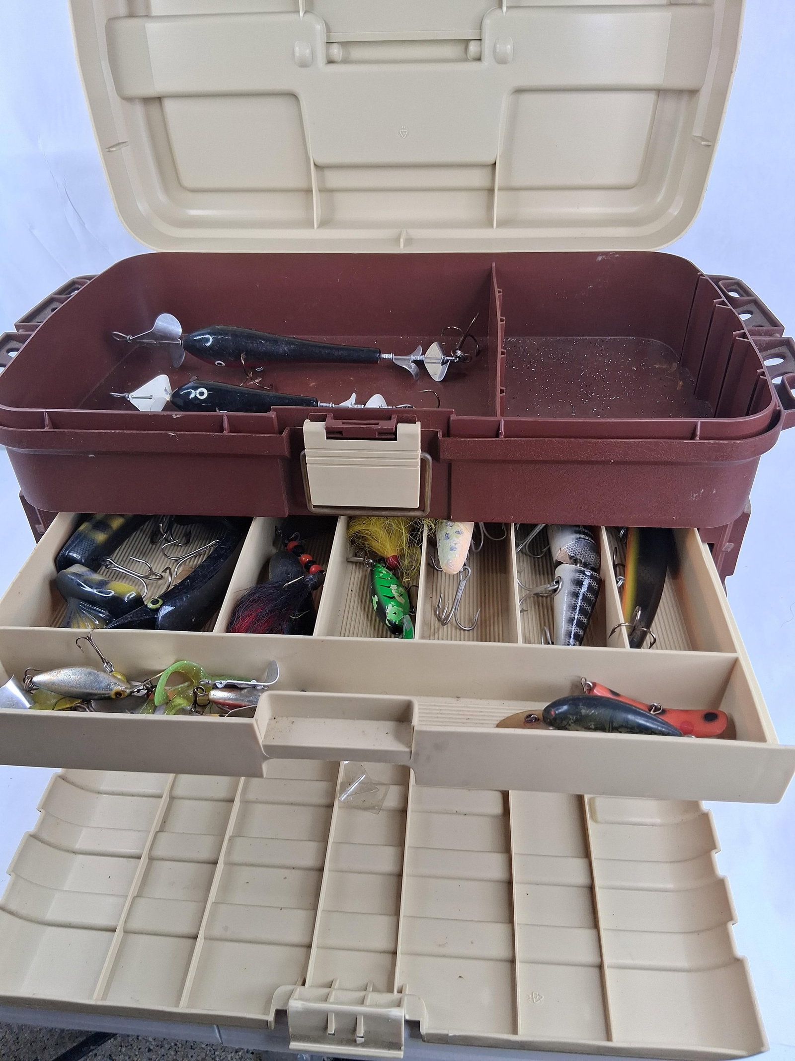Plano Model 758 Tackle Box & Fishing Lures: This Plano Model 758 tackle box is constructed of two-tone tan and brown plastic and features multiple integrated storage trays. The interior of the box is embossed with the markings MODEL 758 PLANO