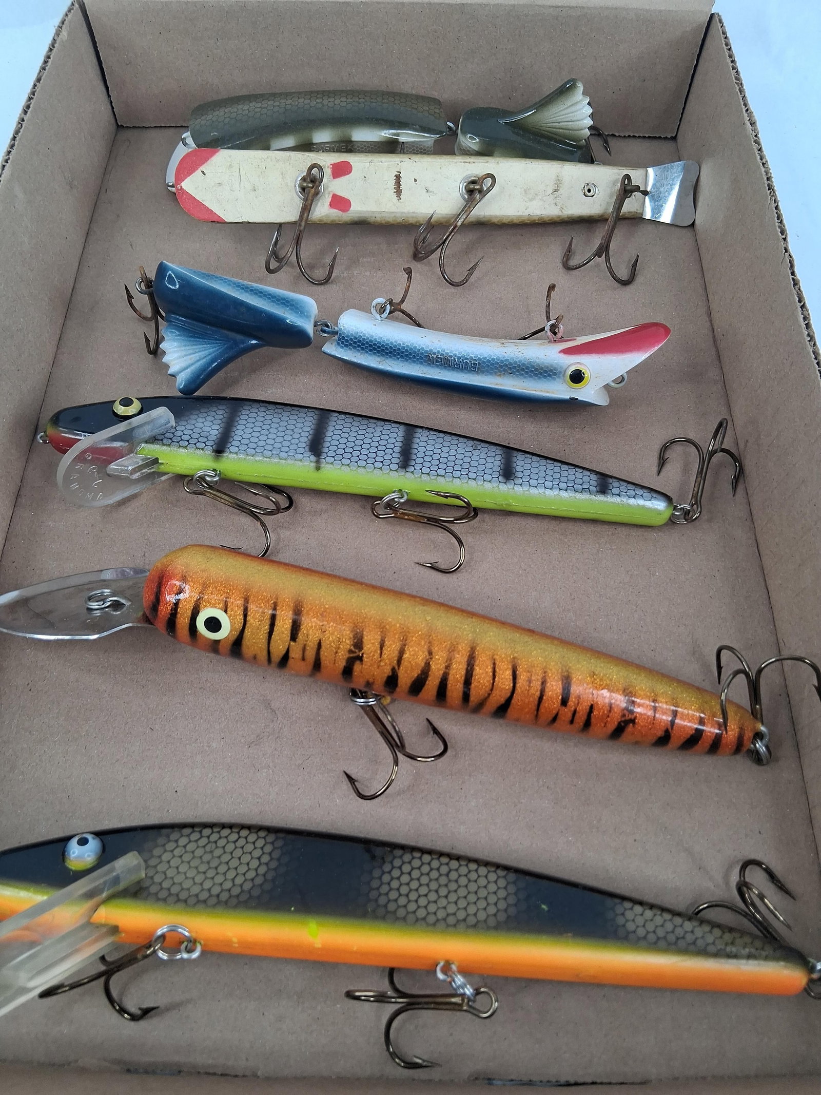 Burmek & Grandma Musky Fishing Lures: 10in long This collection of musky fishing lures includes models marked BURMEK and GRANDMA. The assortment features jointed lures with molded bodies, minnow-style crankbaits with plastic diving lips,