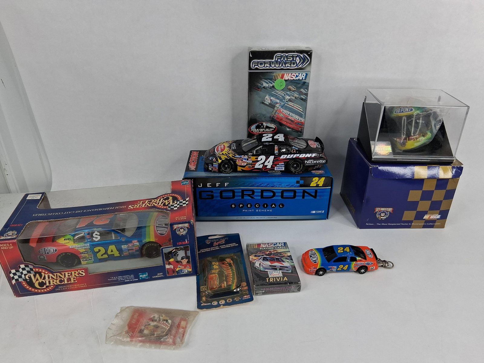 Jeff Gordon NASCAR Memorabilia: Cars & Mini Helmet: This collection features various late 1990s and early 2000s NASCAR memorabilia, primarily focused on driver Jeff Gordon. The group includes a Winner's Circle 1/24 scale die-cast model of Jeff