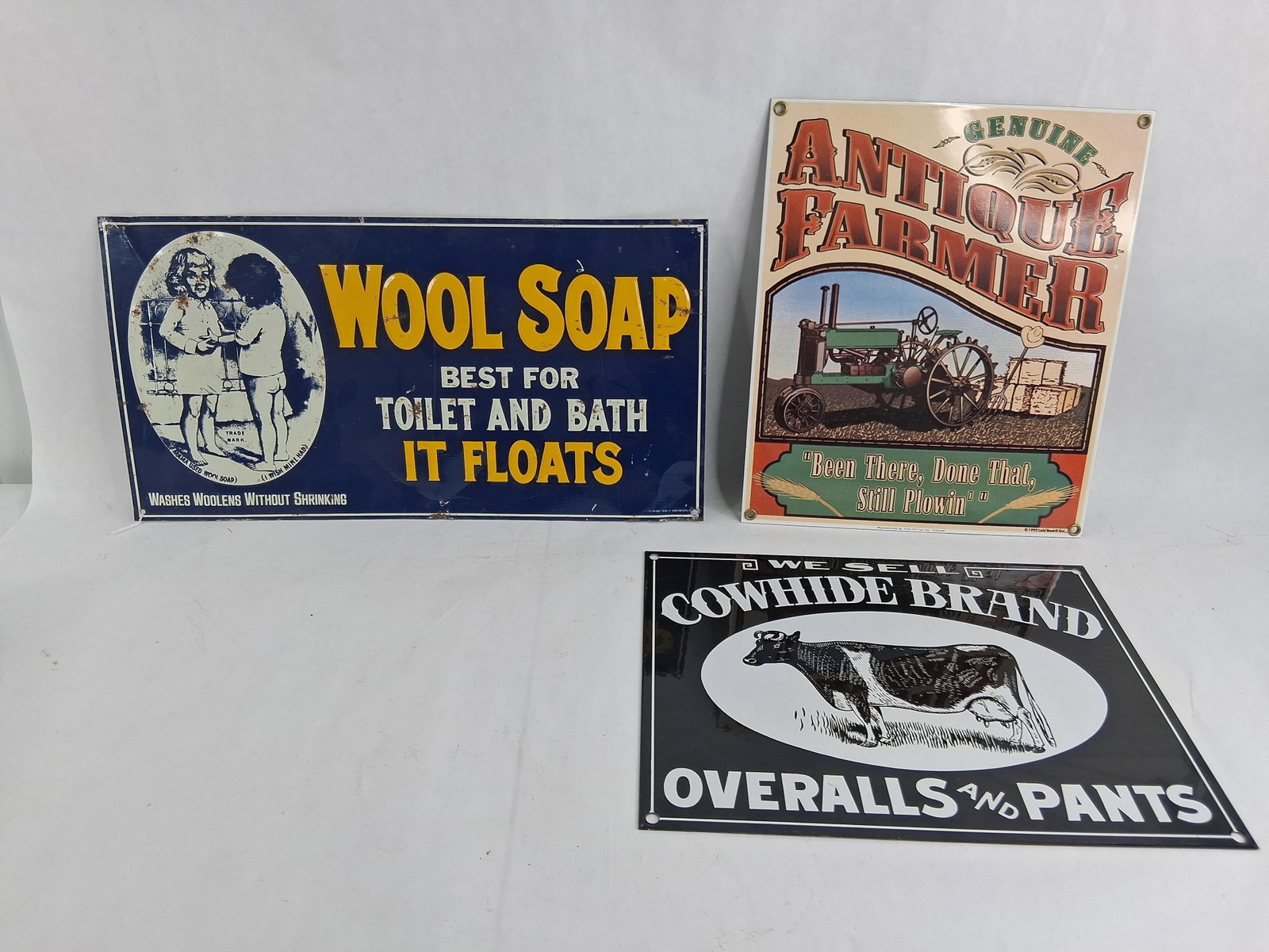Set 3 Metal Advertising Signs: largest is 15.5 in long This lot consists of three metal advertising signs featuring early 20th-century style graphics produced in the late 20th century. The first is a rectangular, horizontally