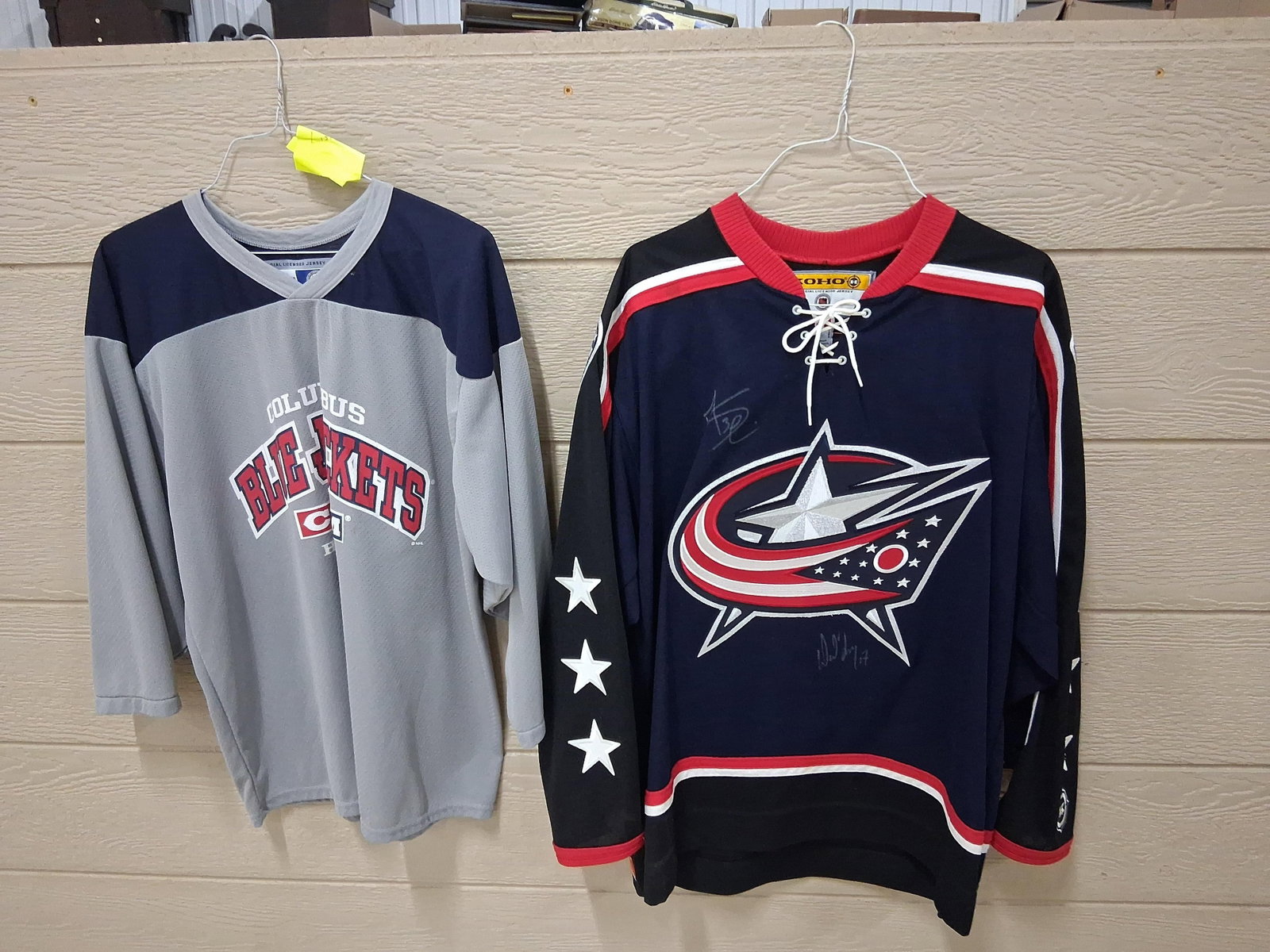 Pair Columbus Blue Jackets Jerseys, Signed KOHO: This lot consists of two Columbus Blue Jackets NHL jerseys from the early 2000s era. The first item is a navy blue KOHO brand official licensed replica jersey featuring a lace-up collar and the team's