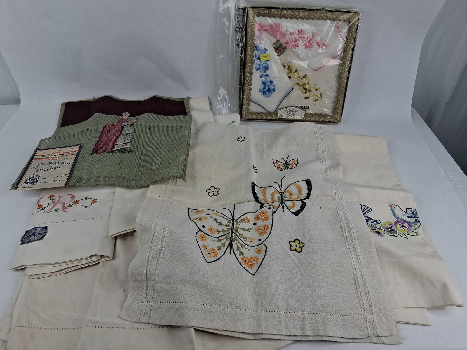 Linens, Handkerchiefs & Hiawatha Needlepoint: This collection includes a variety of household textiles and needlework items, primarily dating from the mid-20th century. The assortment features several white cotton pillowcases with