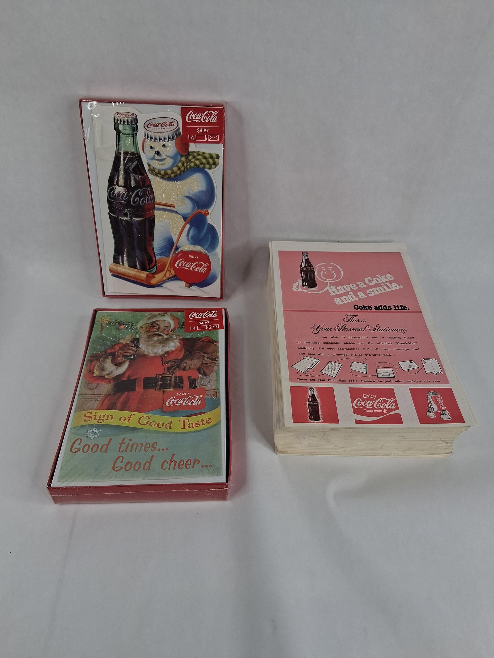 Coca-Cola Ephemera: Holiday Cards & Stationery Pad: This group lot features three pieces of Coca-Cola branded paper ephemera consisting of two boxed sets of holiday greeting cards and one personal stationery pad. The two card sets each contain 14