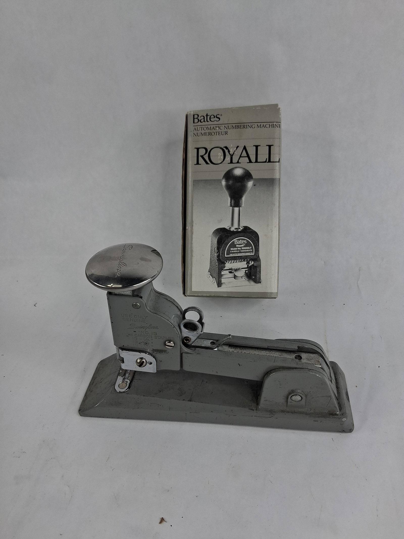 Swingline Stapler & Bates Numbering Machine: This lot features two pieces of American office equipment: a Swingline No. 13 heavy-duty stapler and a Bates Royall automatic numbering machine. The stapler is constructed with a cast metal base