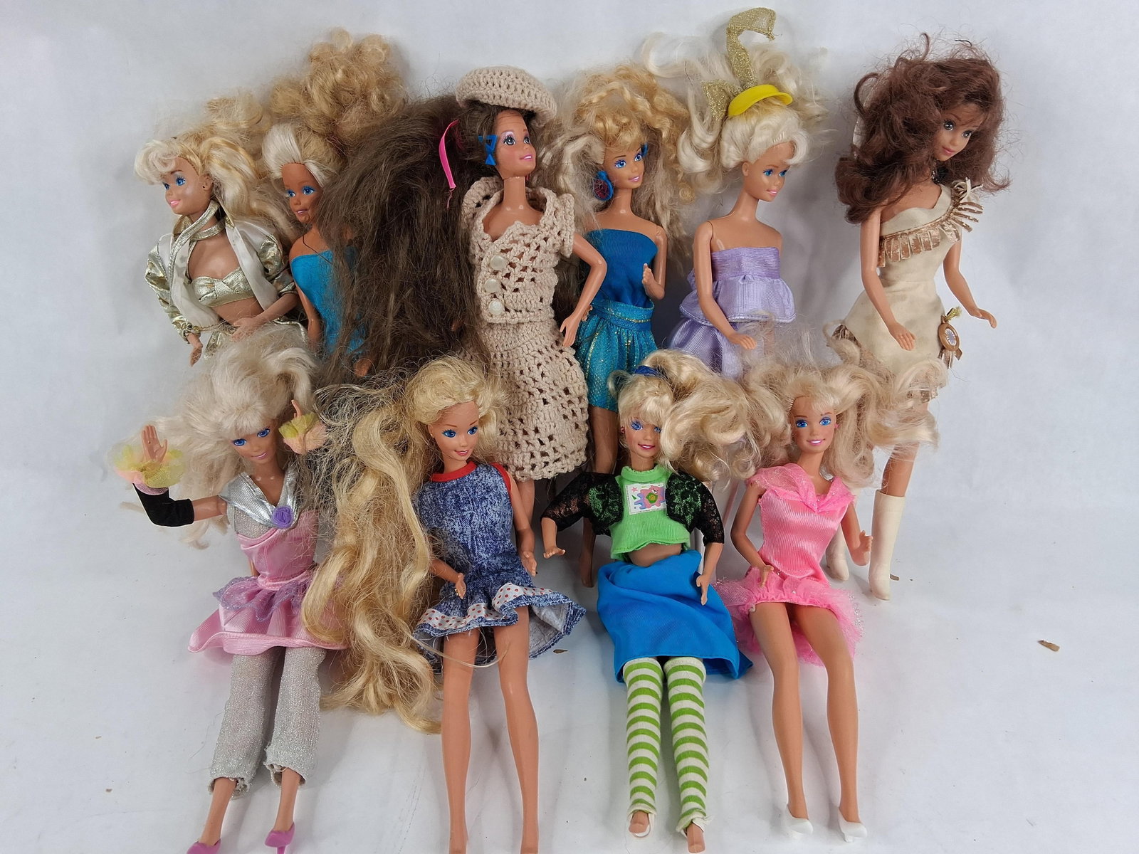 11 & Modern Mattel Barbie Fashion Dolls: A lot of 11 Mattel fashion dolls, predominantly Barbie, including various releases from the 1980s and 1990s. The dolls are constructed of vinyl with rooted synthetic hair in shades of blonde and