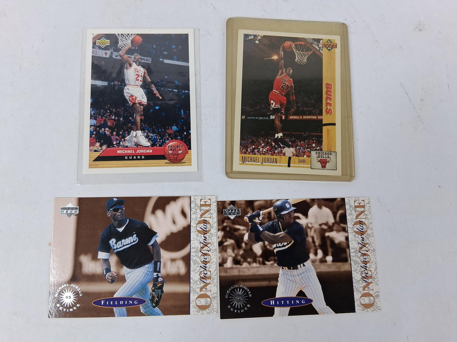 Upper Deck Michael Jordan Trading Cards, Set 4: A collection of four Michael Jordan trading cards produced by Upper Deck between 1991 and 1995. The lot includes a 1991-92 Upper Deck basketball card #1 depicting Jordan in a red Chicago Bulls away je