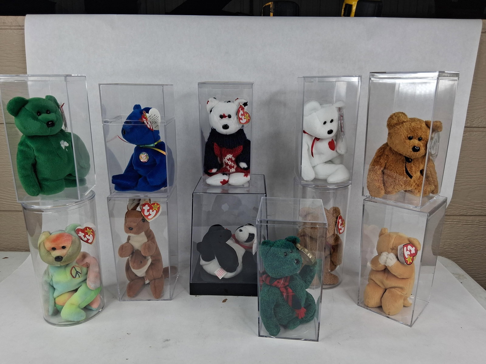 11 Ty Beanie Babies w/ Display Cases: An assortment of eleven Ty Beanie Babies manufactured by Ty Inc., Oakbrook, Illinois. The collection includes various plush figures constructed from colorful polyester fabric, featuring plastic eyes