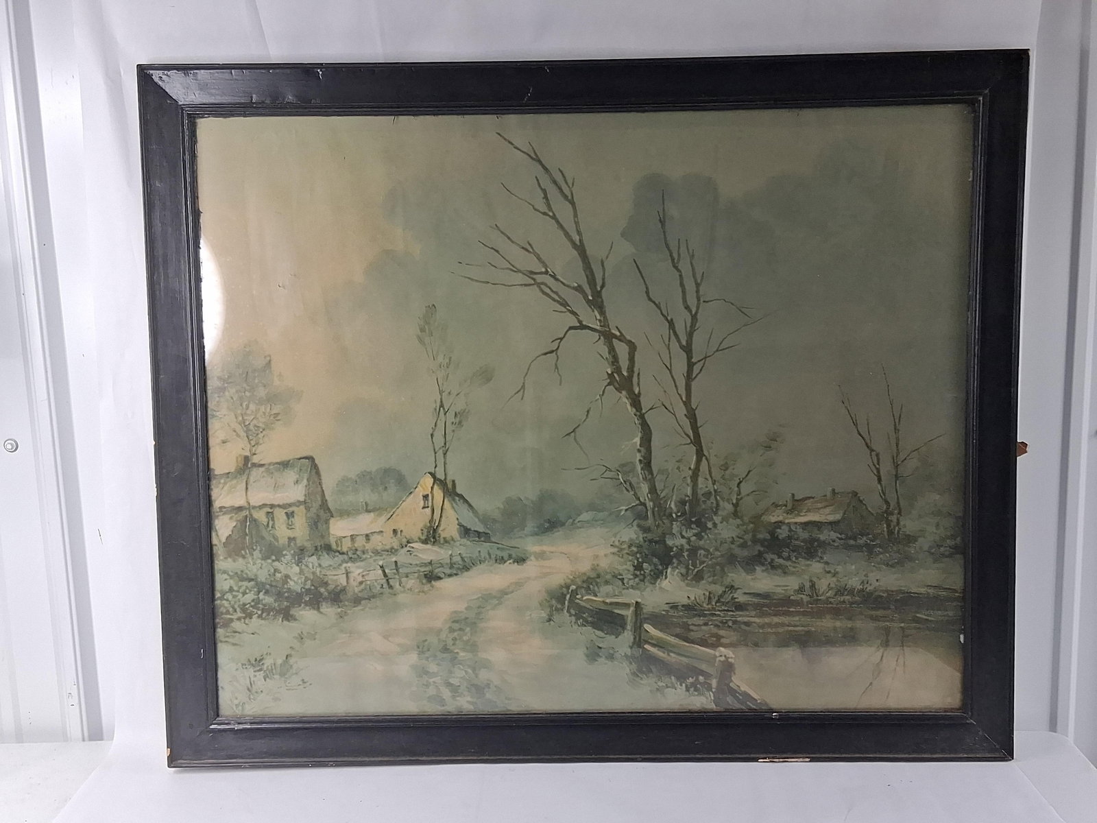 American School, 20th C. Winter Silence Landscape: 23.5x27.5This atmospheric winter landscape is rendered in watercolor with gouache highlights on toned paper. The composition depicts a quiet, snowy scene with a rutted path winding between two gabled 