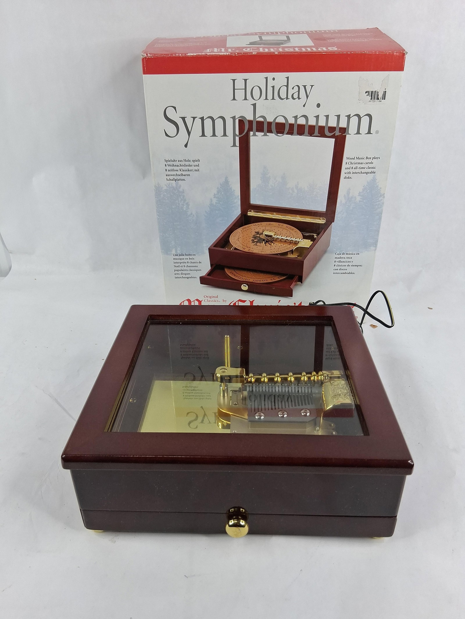 Mr. Christmas Wood Holiday Symphonium w/ 16 Disks: This lot features a Mr. Christmas Holiday Symphonium mechanical disk-player music box. The unit is housed in a polished dark wood case with a hinged lid containing a glass viewing window and