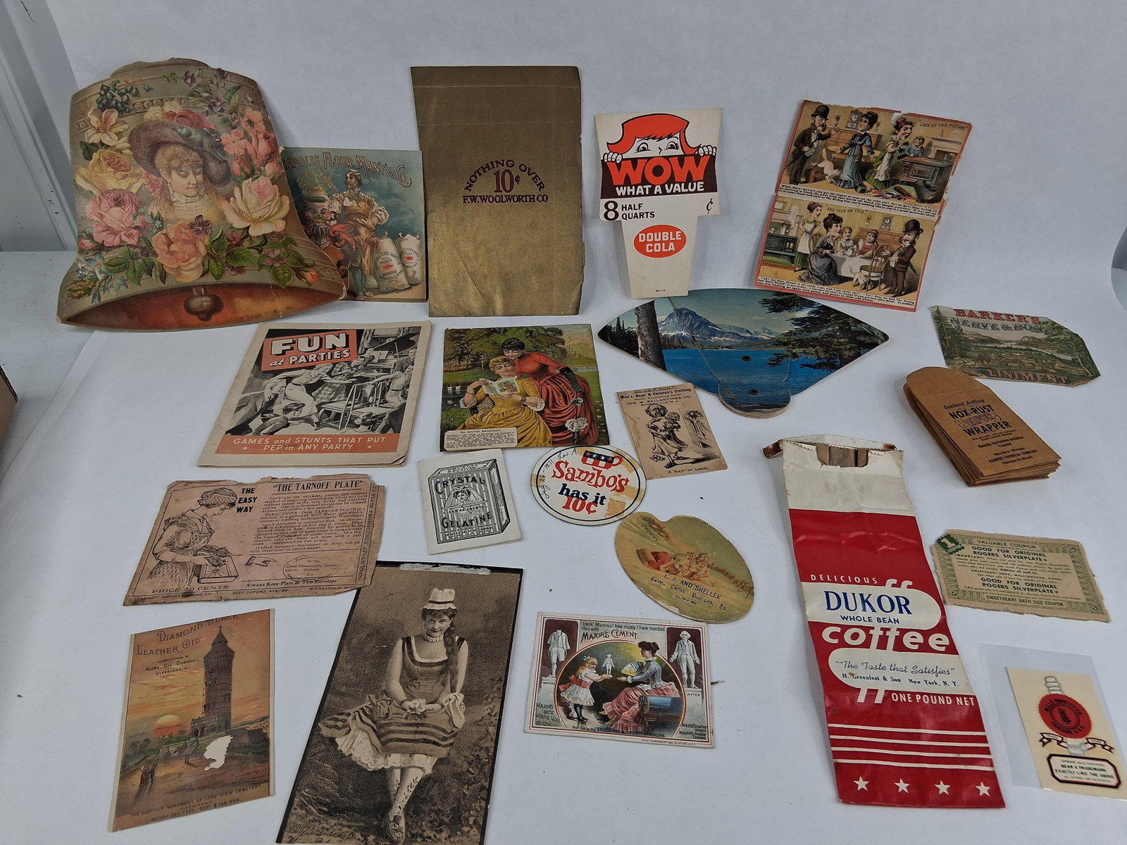 American Advertising Ephemera, 1883-1971: This lot comprises an assortment of American paper ephemera and advertising materials spanning the late 19th to the mid-20th centuries. A primary item is a large die-cut, bell-shaped floral print date