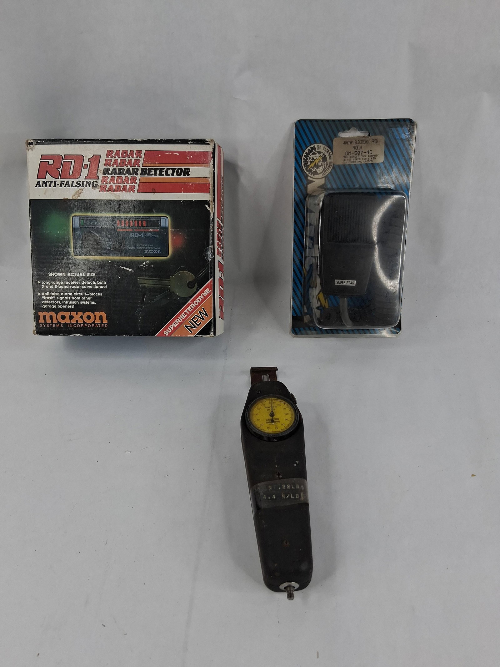 A Trio of Electronic and Mechanical Devices including a Maxon Radar Detector, Workman CB: This lot features three items: a radar detector, a CB microphone, and a mechanical force gauge. The radar detector is a Maxon Systems, Inc. model RD-1 Anti-Falsing dual superheterodyne unit, which
