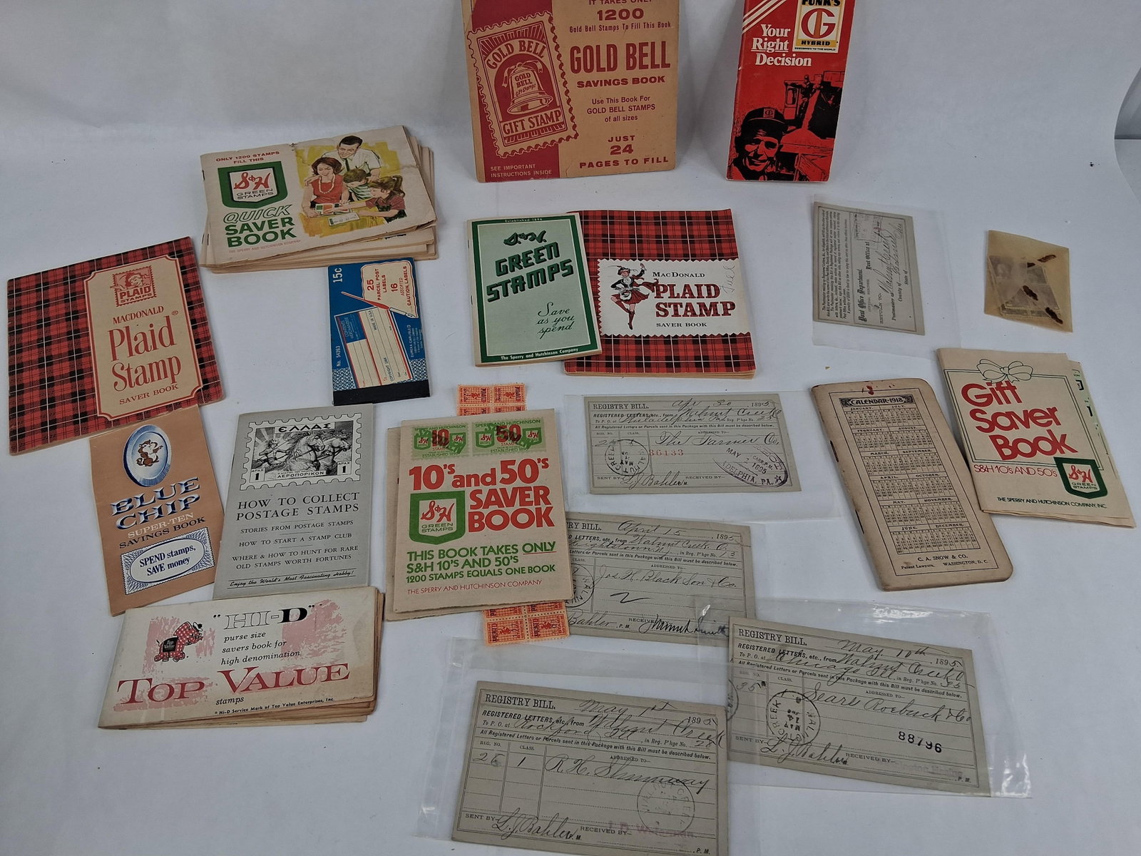 Trading Stamp Books, 1895 Ohio Bills & Ephemera: This lot comprises an assortment of mid-20th-century consumer trading stamp books, late 19th-century postal documents, and international philatelic materials. The collection includes multiple trading