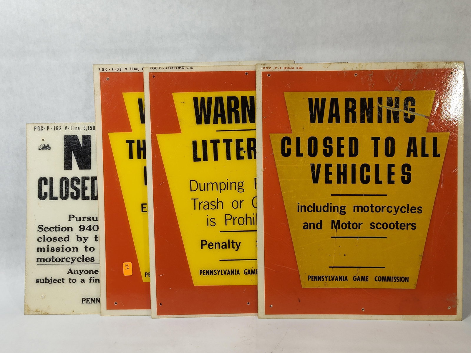 Vtg Pennsylvania Game Commission Metal Signs: This group of four vintage screen-printed metal regulatory signs was issued by the Pennsylvania Game Commission. The collection consists of three orange and yellow keystone-shaped warning signs and on