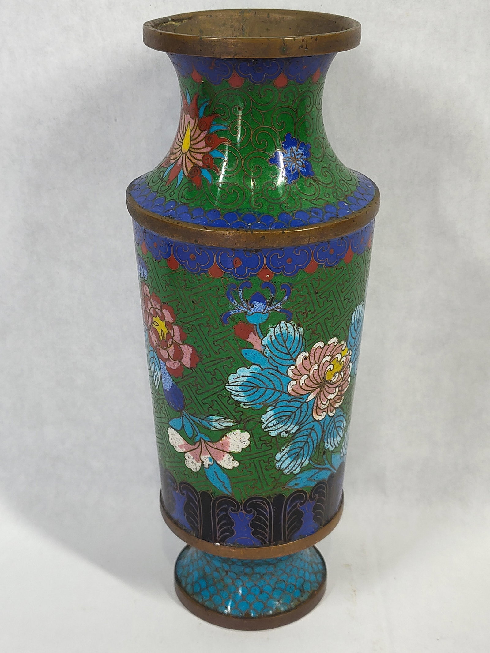 Chinese Green Ground Cloisonne Floral Vase, c.1900: A Chinese cloisonne enamel vase featuring a tapering cylindrical body with a rounded shoulder, a waisted flared neck, and a spreading circular foot. The vessel is constructed of a brass base with wire