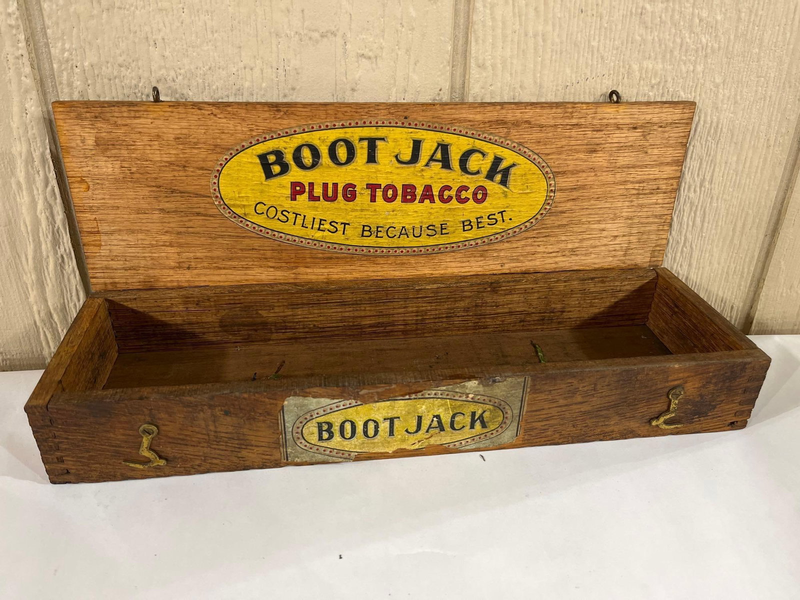American Tobacco Co. Oak Boot Jack Display Box: An antique wooden counter-top display box for Boot Jack Plug Tobacco. The box is of rectangular form and is constructed from oak with finger-jointed corners and a hinged lid. The interior of the lid