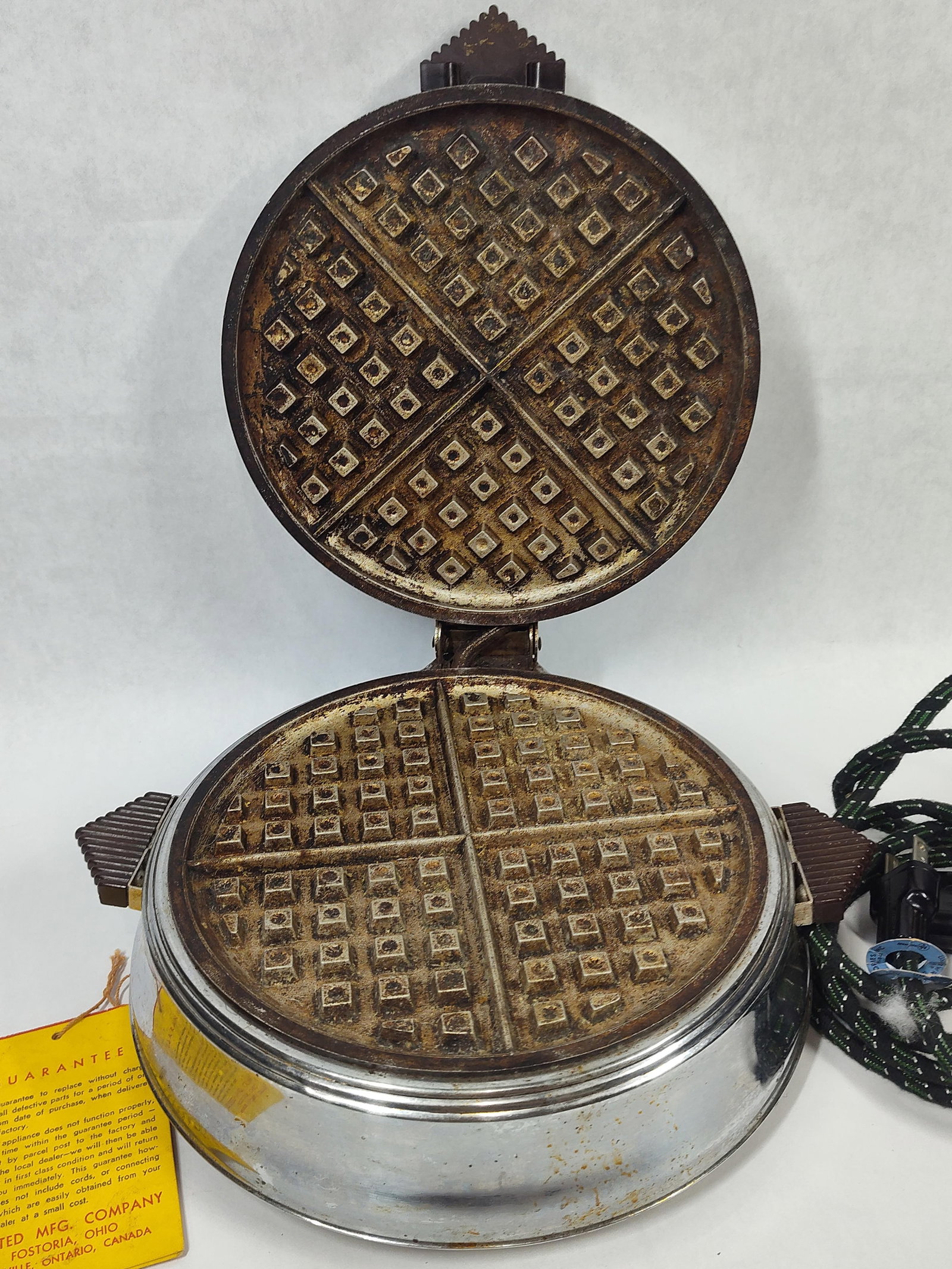 Bersted Mfg. Art Deco Chrome Waffle Iron w/ Tag: This vintage electric waffle iron is manufactured by the Bersted Mfg. Company of Fostoria, Ohio, and Oakville, Ontario, Canada. The unit features an Art Deco-style chrome-plated circular housing with