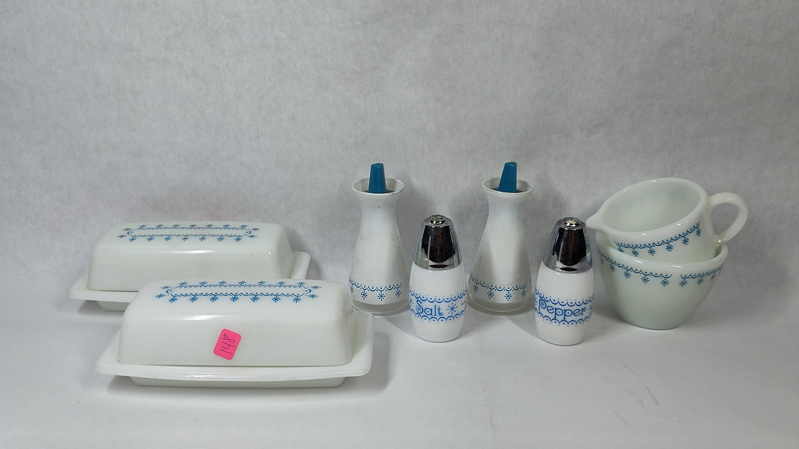 Pyrex Snowflake Garland Milk Glass Kitchen Set: This collection of opaque white milk glass kitchen items features the Snowflake Garland pattern, produced by Pyrex (Corning). The decoration consists of a blue scalloped border interspersed with
