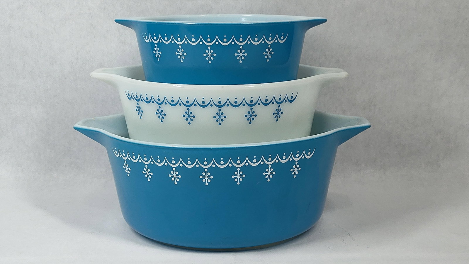 Pyrex Snowflake Garland Nesting Casserole Trio: This set comprises three Pyrex nesting bowls in the Snowflake Garland pattern, manufactured by Corning Glass Works in the United States. These bowls were produced between approximately 1972 and 1975. 
