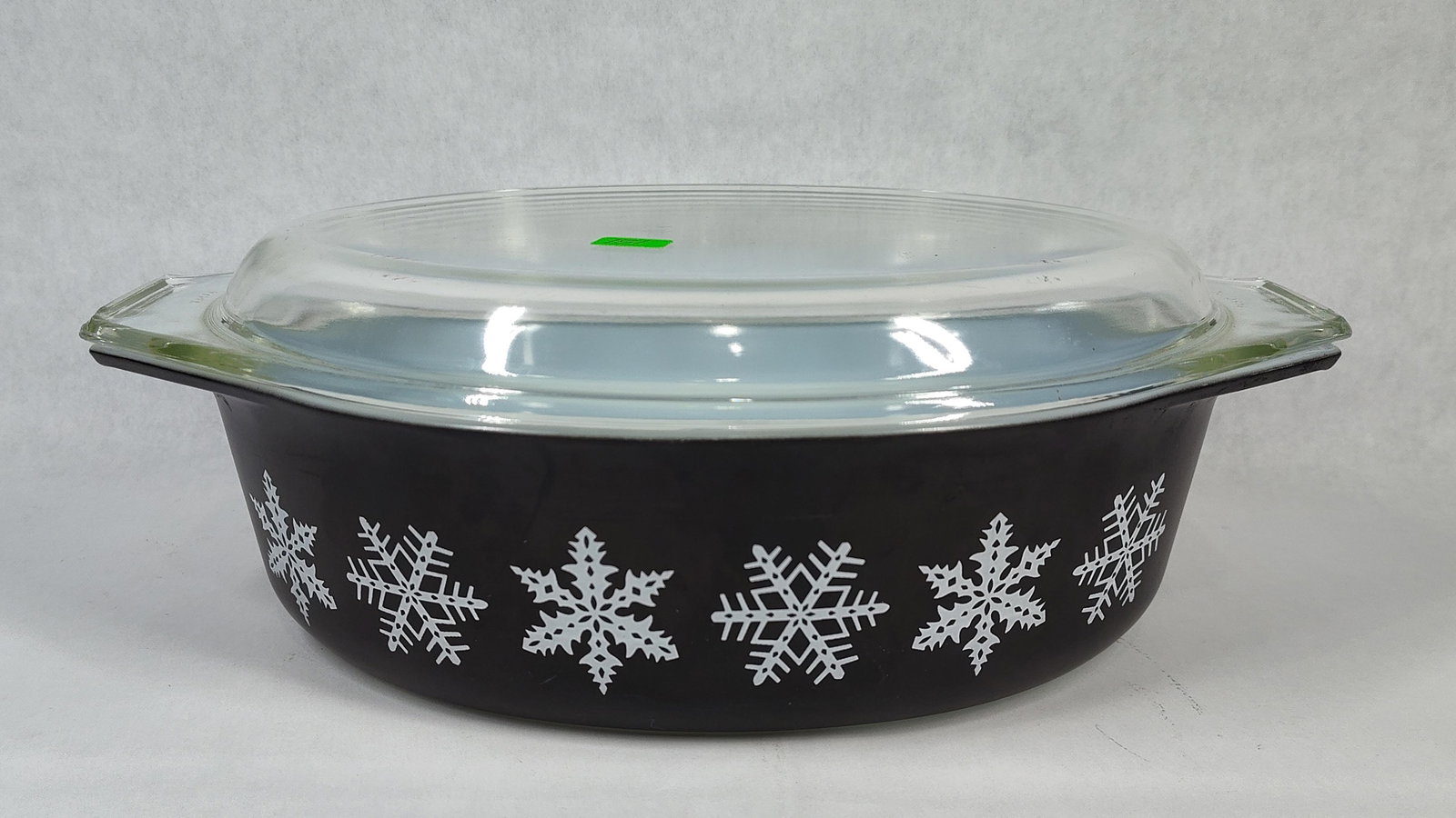 Pyrex Snowflake Charcoal Oval Casserole w/ Lid 045: This vintage Pyrex oval casserole dish features the Snowflake Charcoal pattern. The dish is constructed of white opal glass with a deep charcoal gray fired-on exterior finish. The exterior is