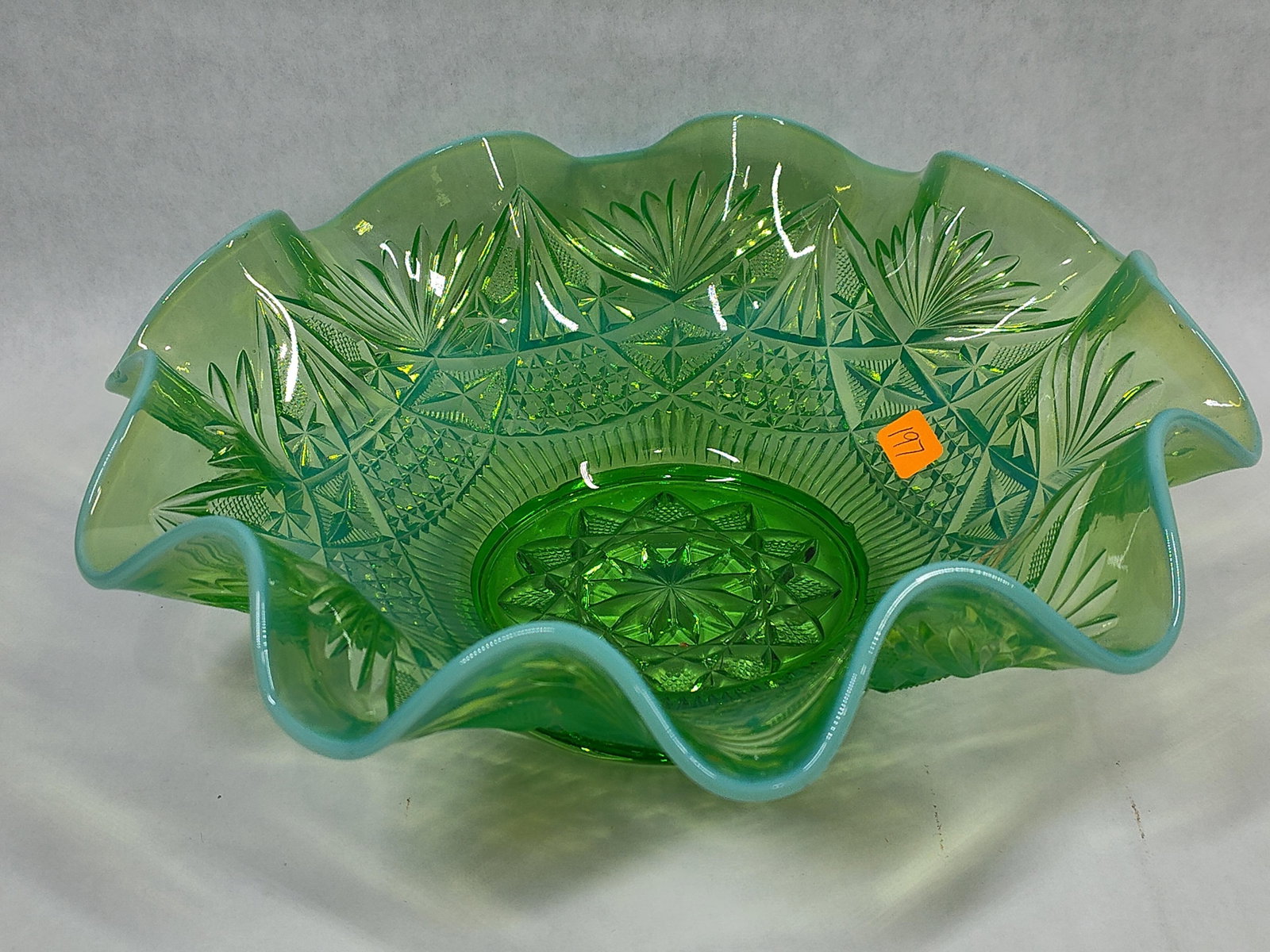 Feather & Star Green Opalescent Glass Ruffled Bowl: This footed ruffled bowl is made of green opalescent pressed glass, attributed to the Northwood Glass Company or Dugan Glass Company. It features the Feather and Star pattern, also known simply as