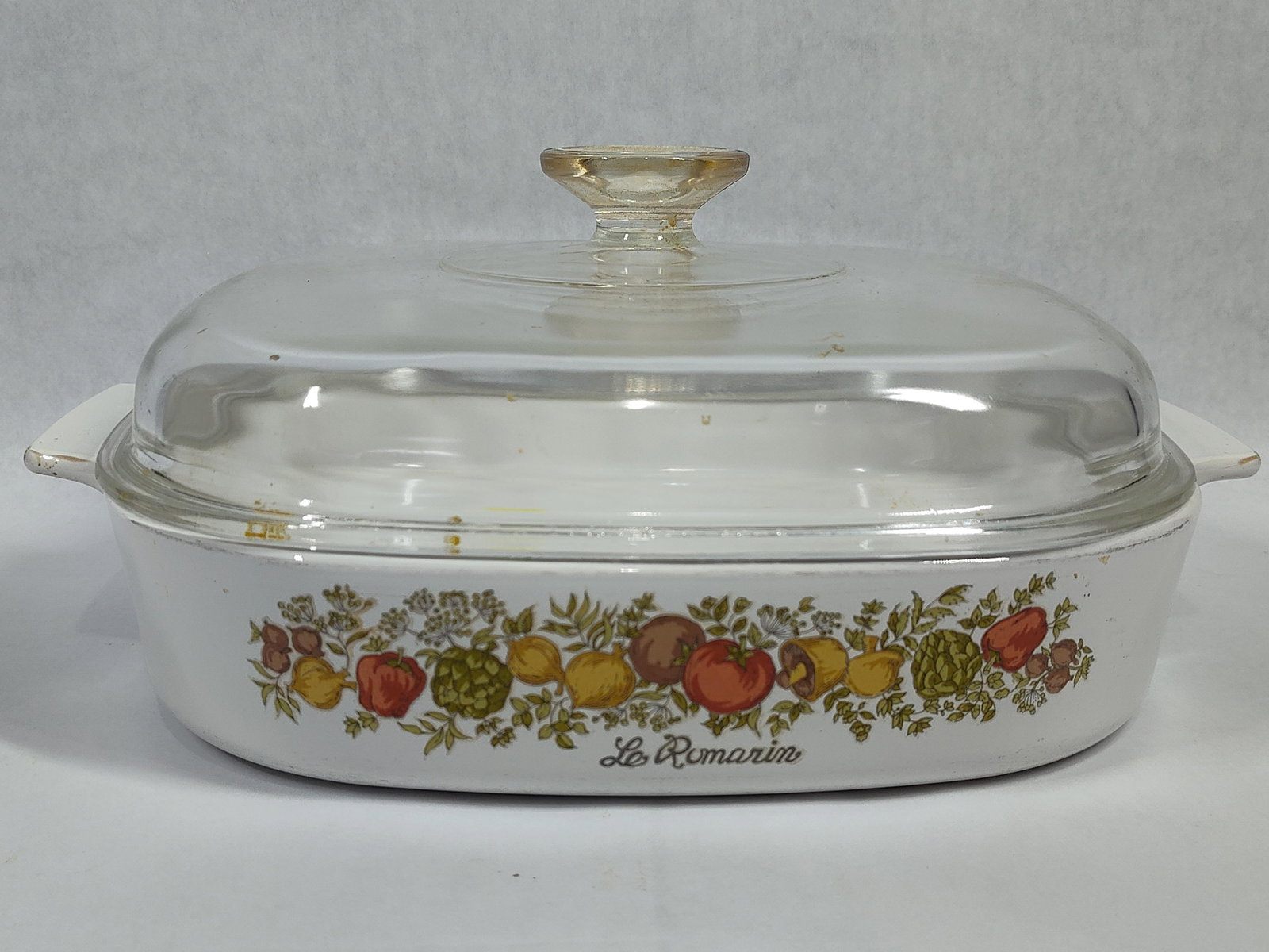 Corning Ware Spice O' Life Casserole w/ Glass Lid: This vintage square casserole dish is manufactured by Corning Ware in the Spice O' Life pattern. The vessel is constructed of white Pyroceram glass-ceramic and features a wrap-around decorative band