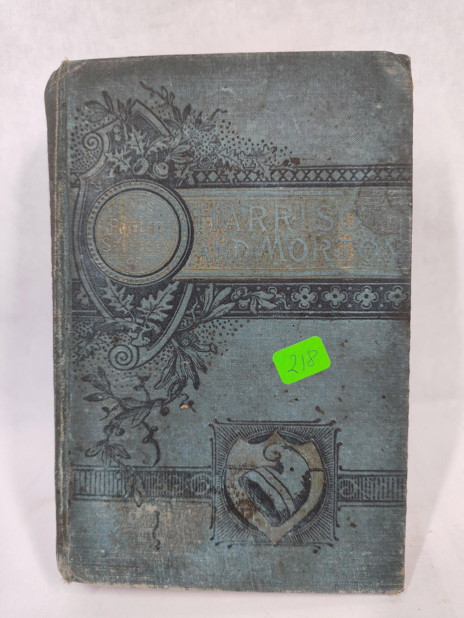 Lives of Benjamin Harrison & Levi P. Morton, 1888: This octavo volume is bound in the original publisher's blue-gray cloth, featuring elaborate black-stamped Victorian decorative motifs on the front cover and spine. The front board displays the title
